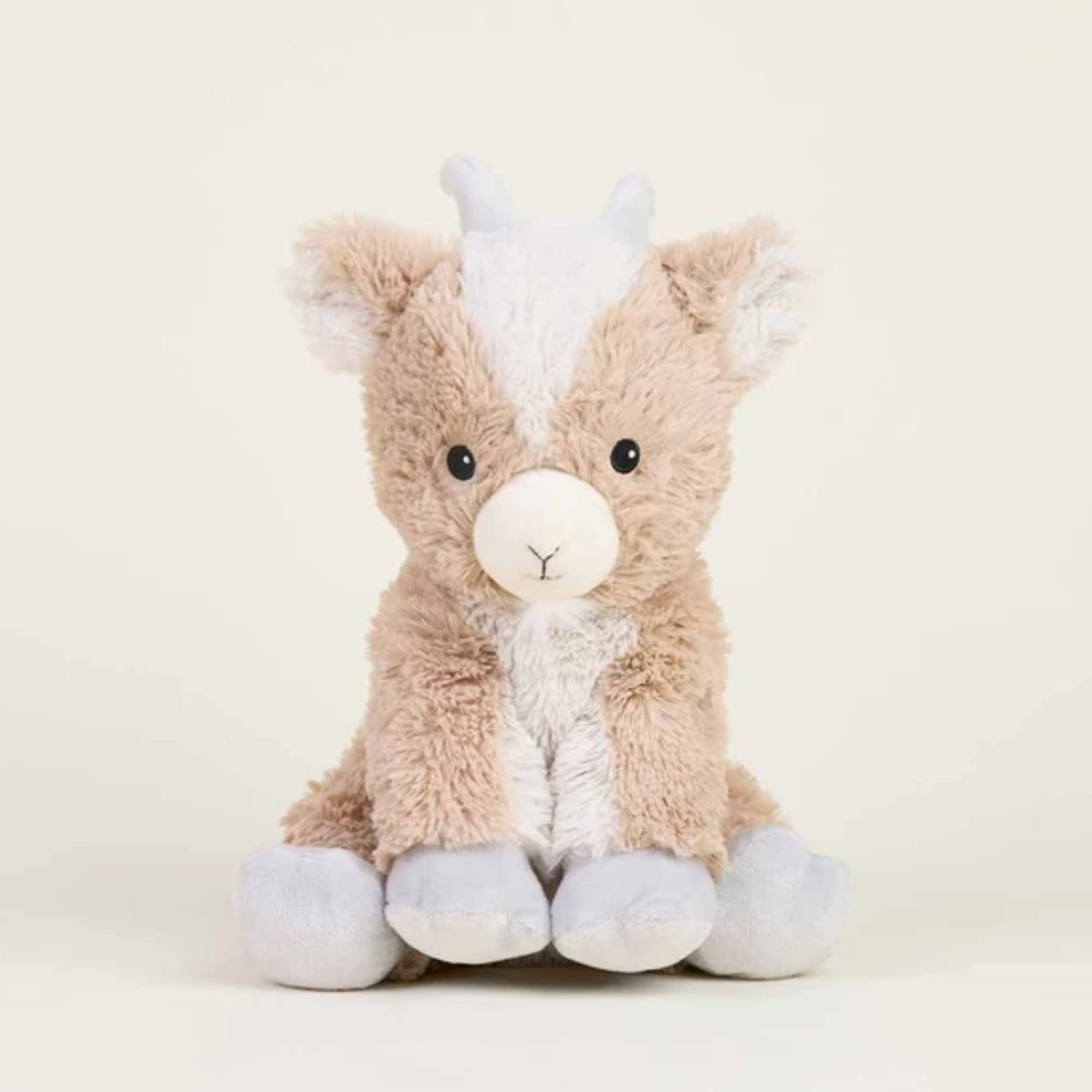 Plush stuffed animal with tan and white fur sitting against a plain background