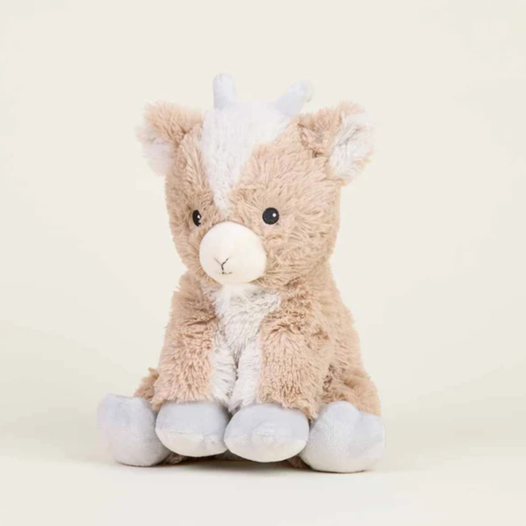 Plush llama toy with beige and white fur sitting against a plain background