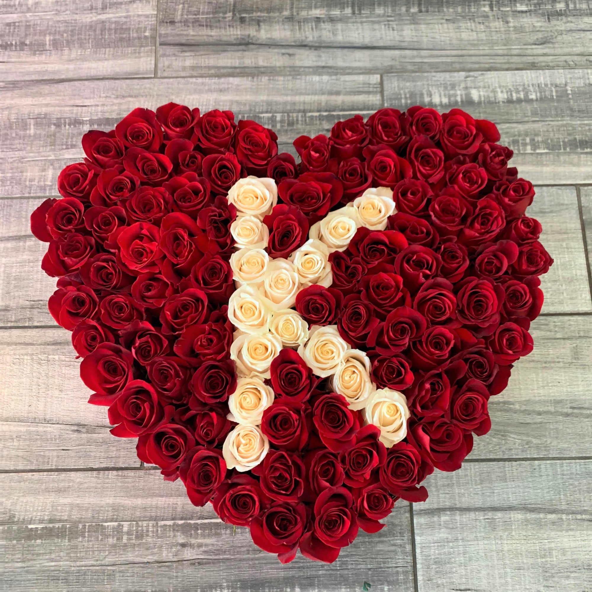 Heart-shaped arrangement of red and cream roses