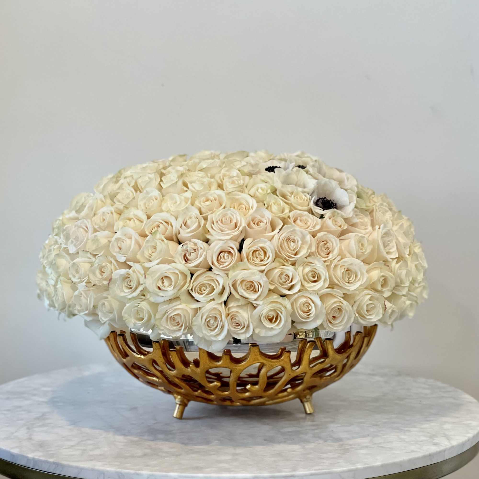 Cream rose arrangement in a gold decorative bowl