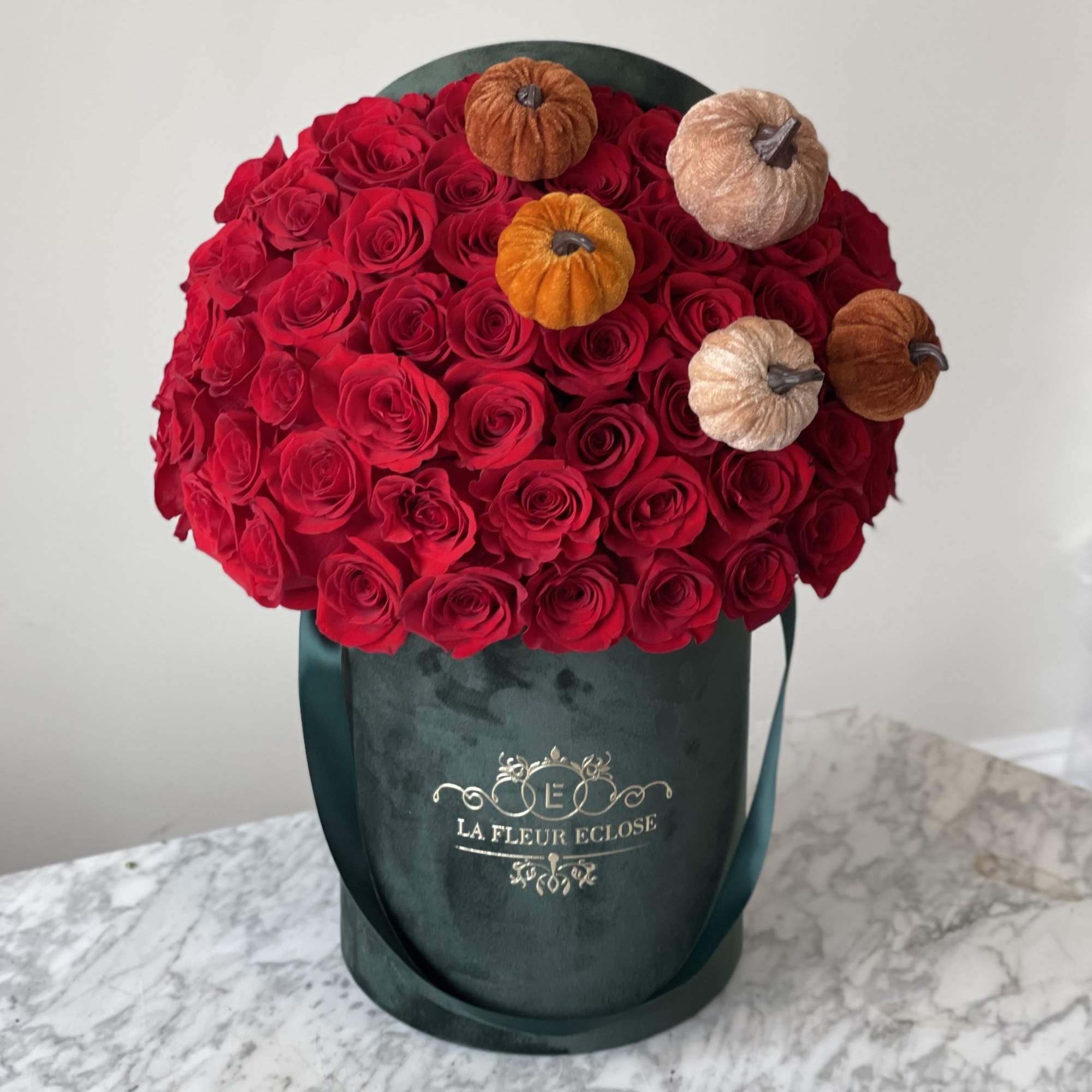 Standard 50 red roses with velvet pumpkins 
Deluxe 75 red roses with
