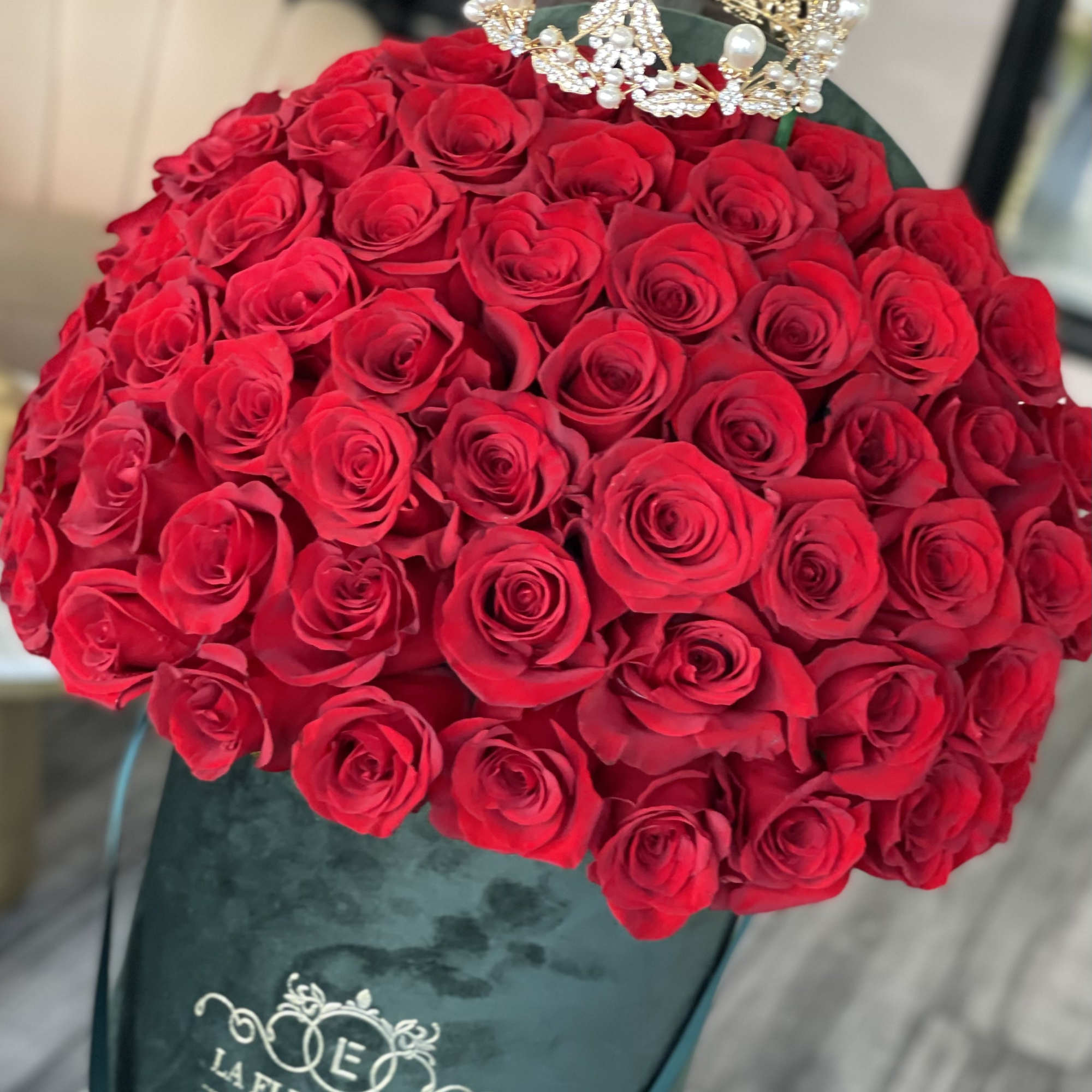 Large bouquet of red roses with a jeweled crown topper