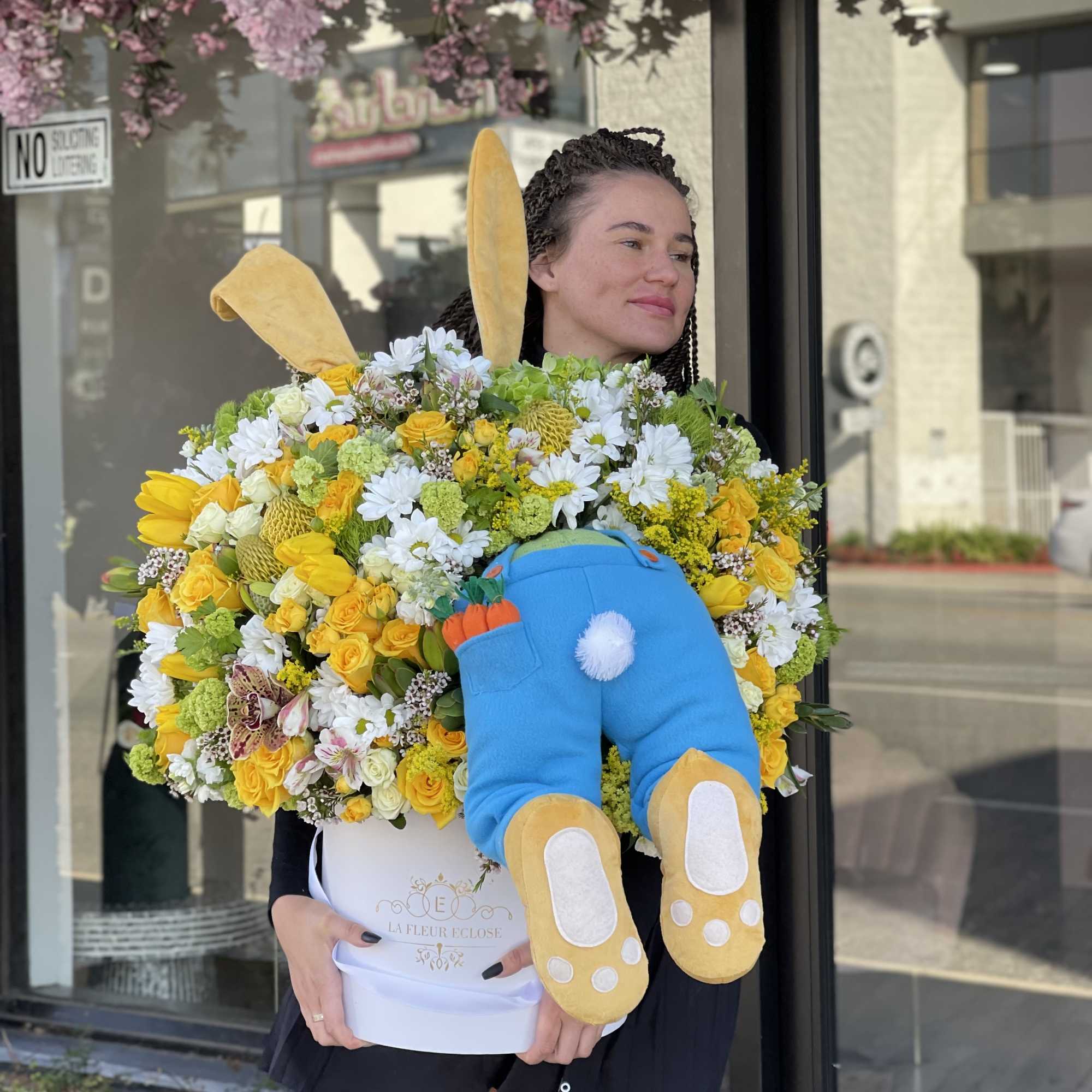 Large yellow and white flower arrangement in a white box with a plush bunny
