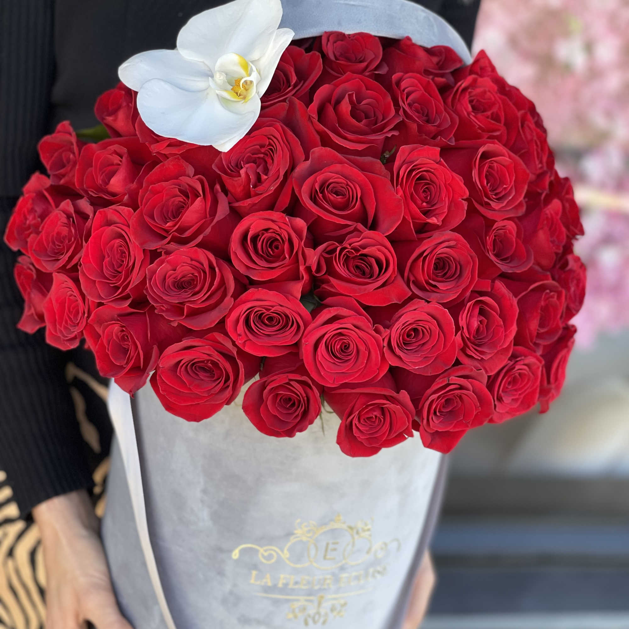 Red roses with one white  orchid, arranged in our grey velvet, photo 2 of 3