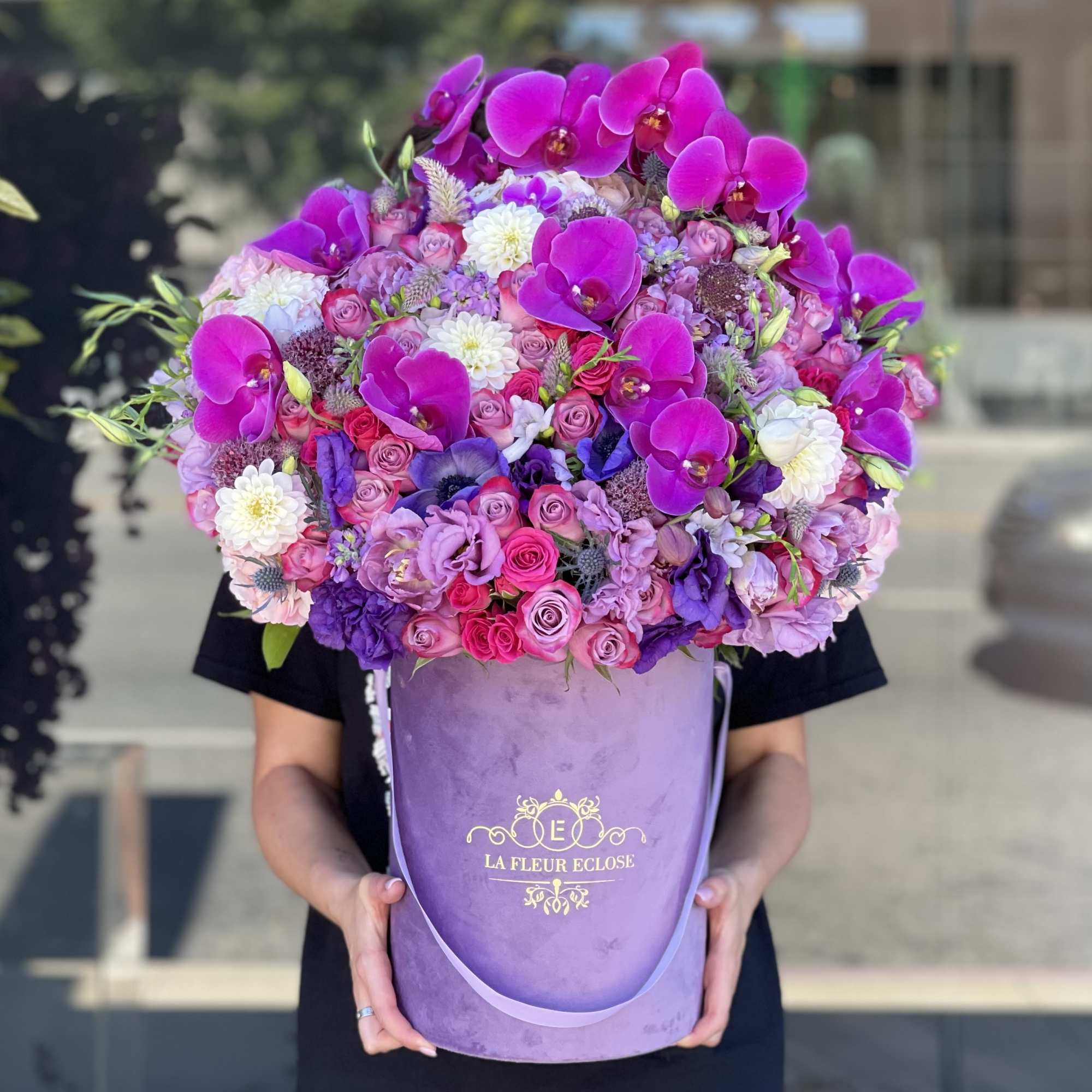 Large purple hatbox arrangement with pink roses and orchids