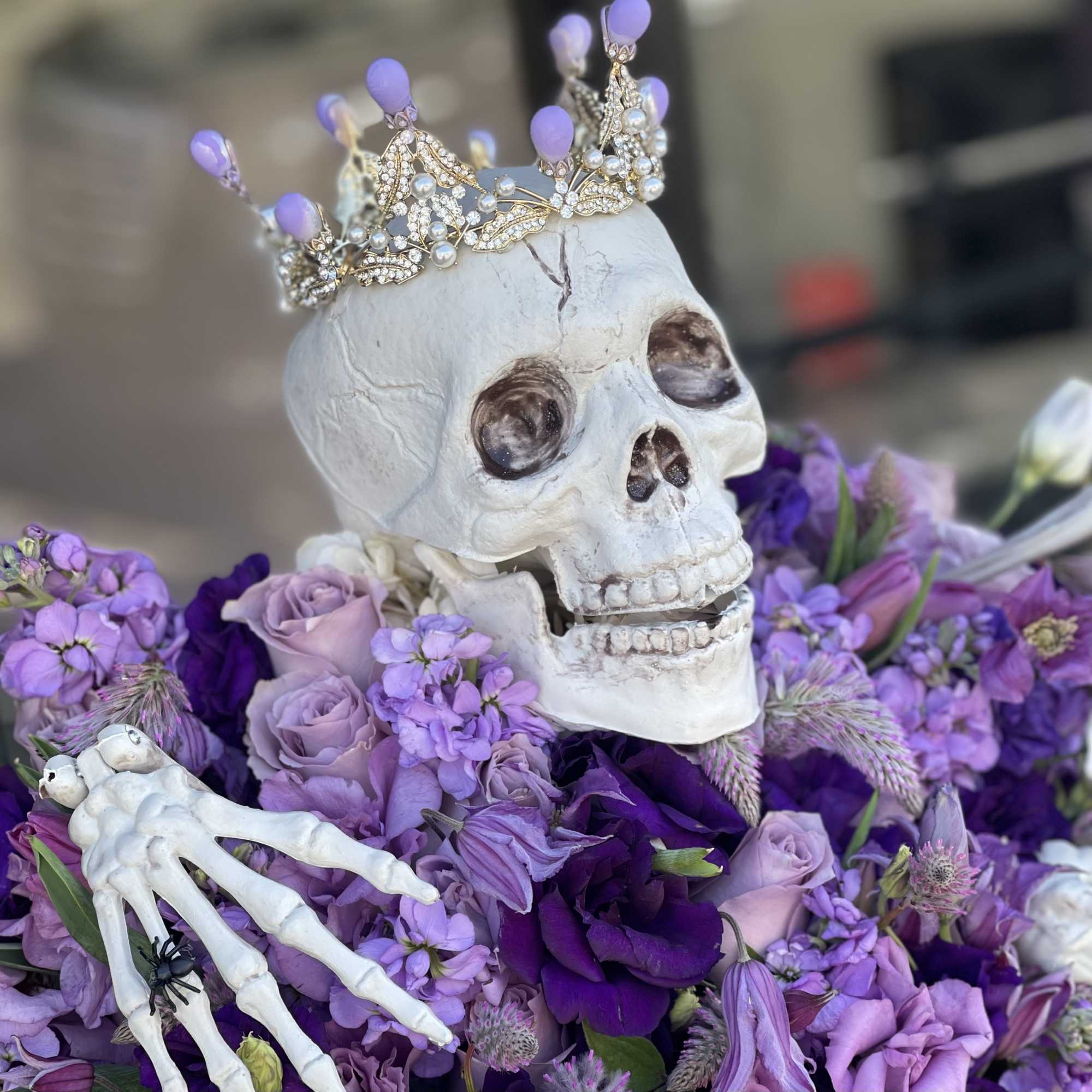 Arrangement of fresh purple and lavender flowers with our scary skeleton with, photo 2 of 3