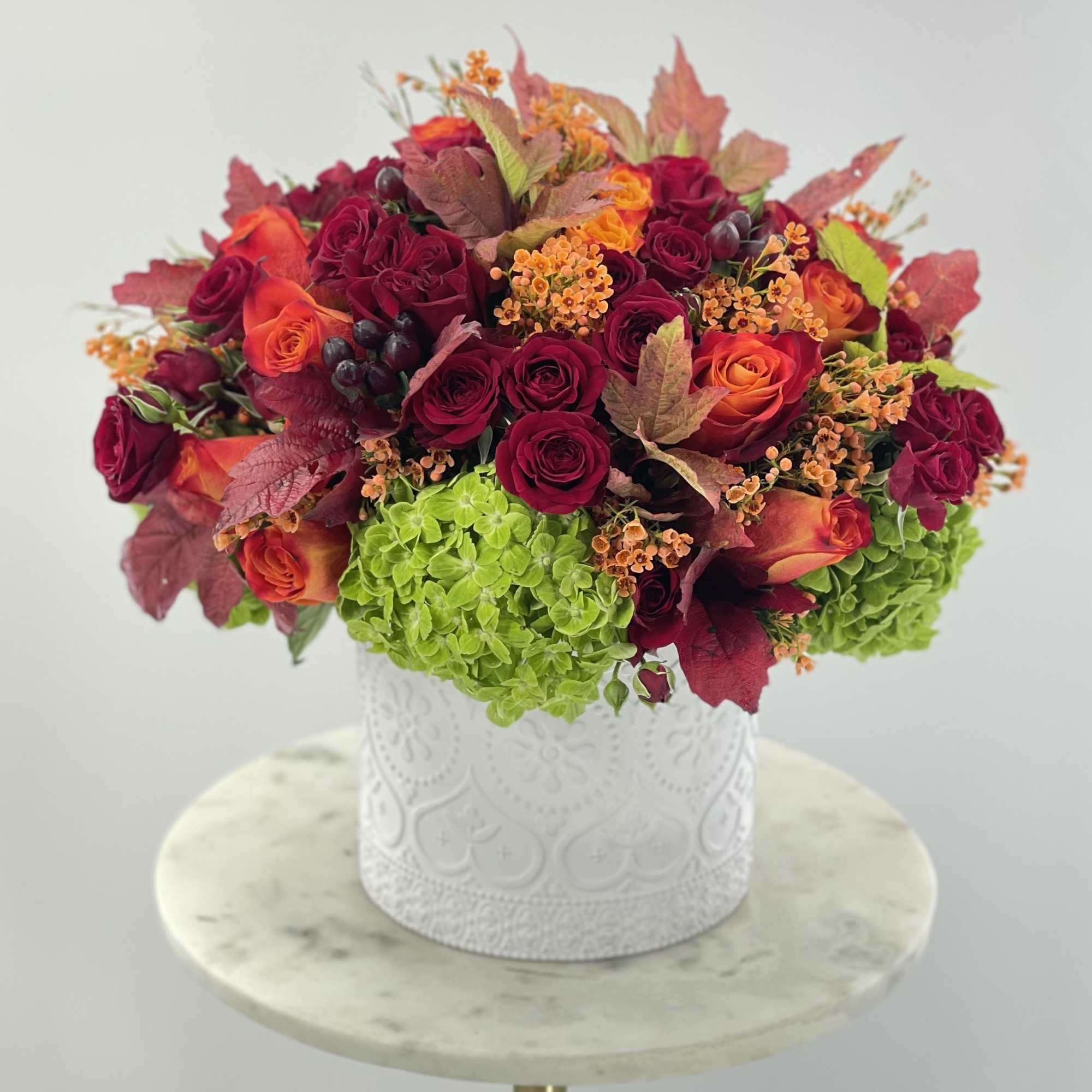 White ceramic vase with fresh bright autumn inspired arrangement 