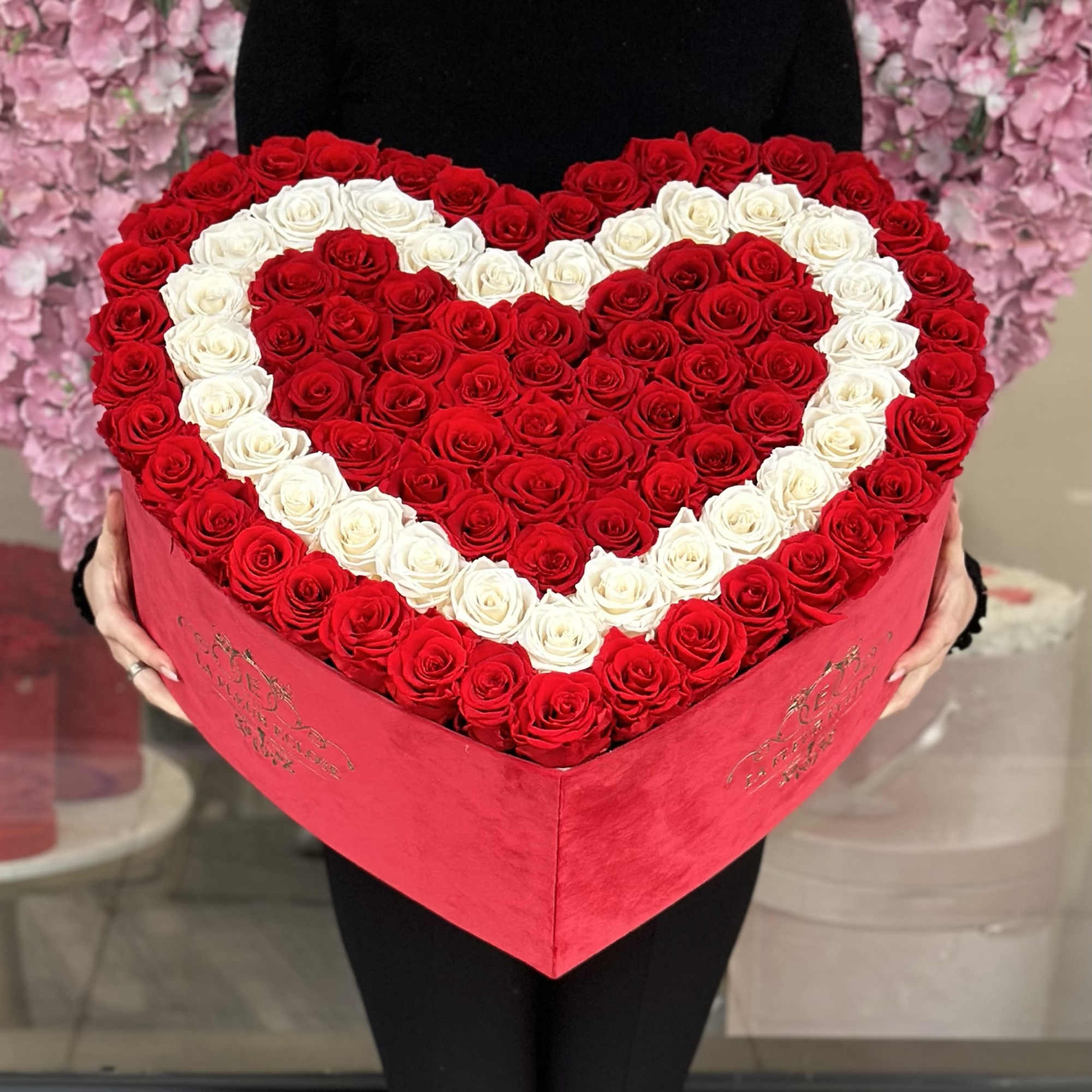 Heart-shaped box filled with red and white roses arranged in a heart pattern