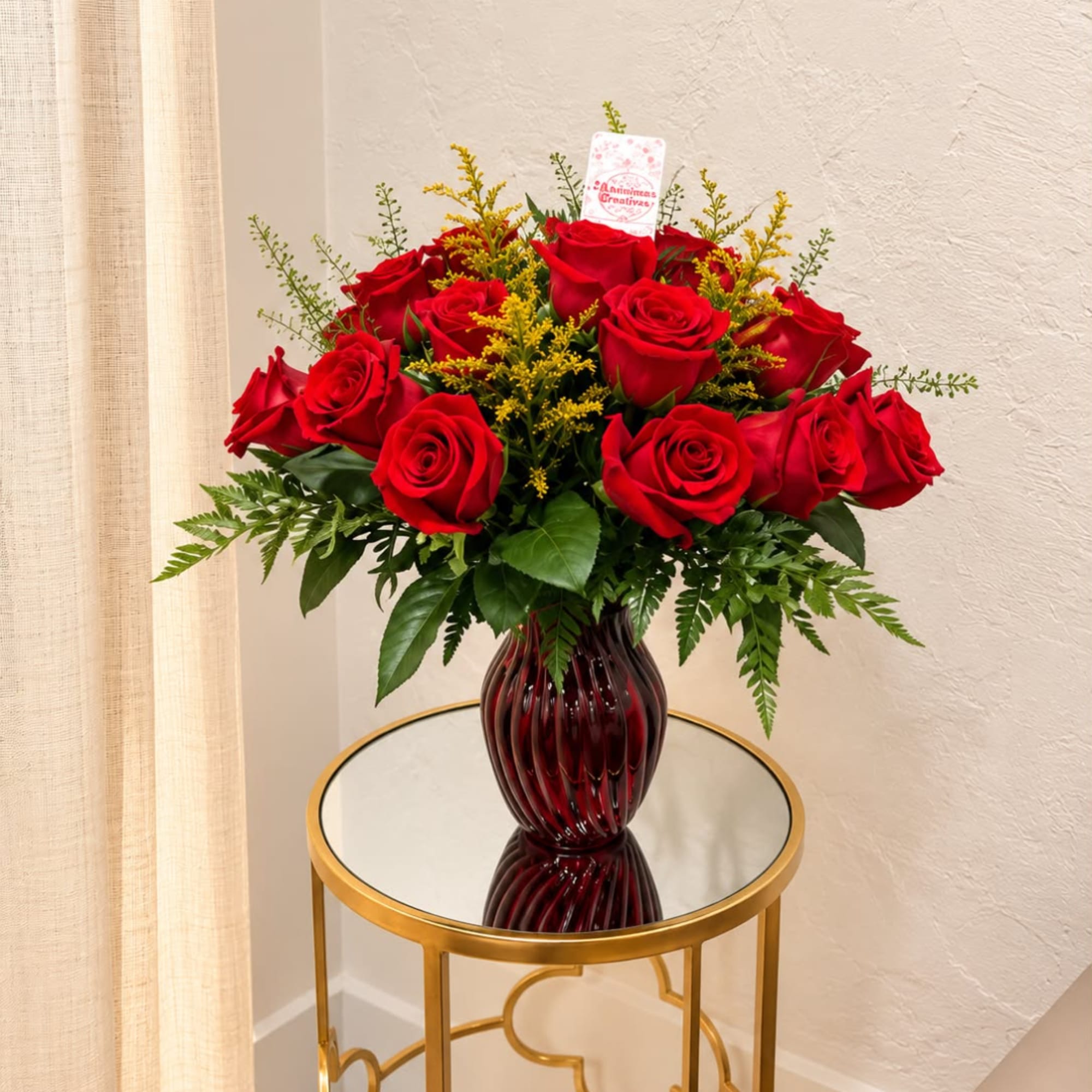 Red roses arranged in a dark glass vase on a round table