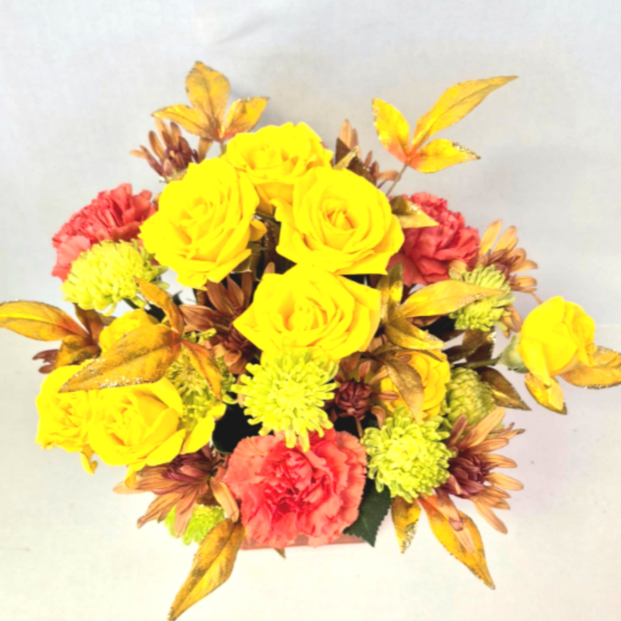 Yellow roses and pink carnations in a compact arrangement