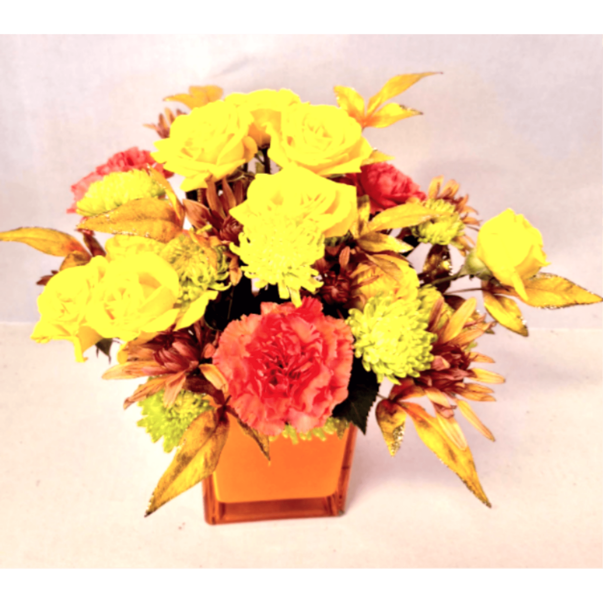 Yellow and coral flowers arranged in an orange square vase