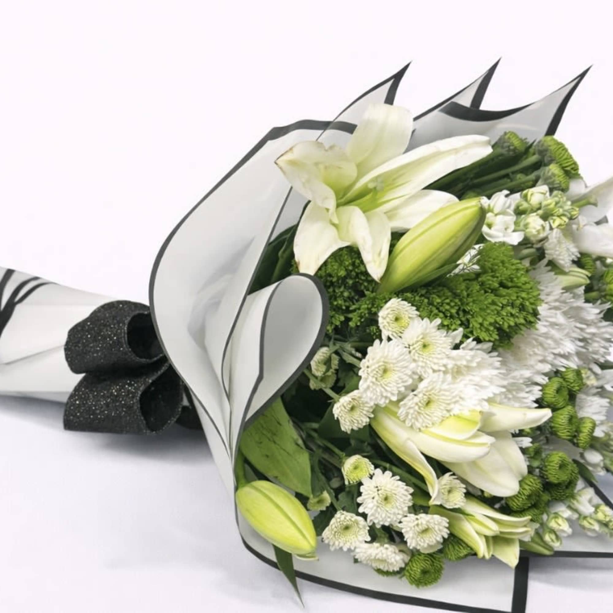 White lily and chrysanthemum bouquet wrapped in black-edged paper