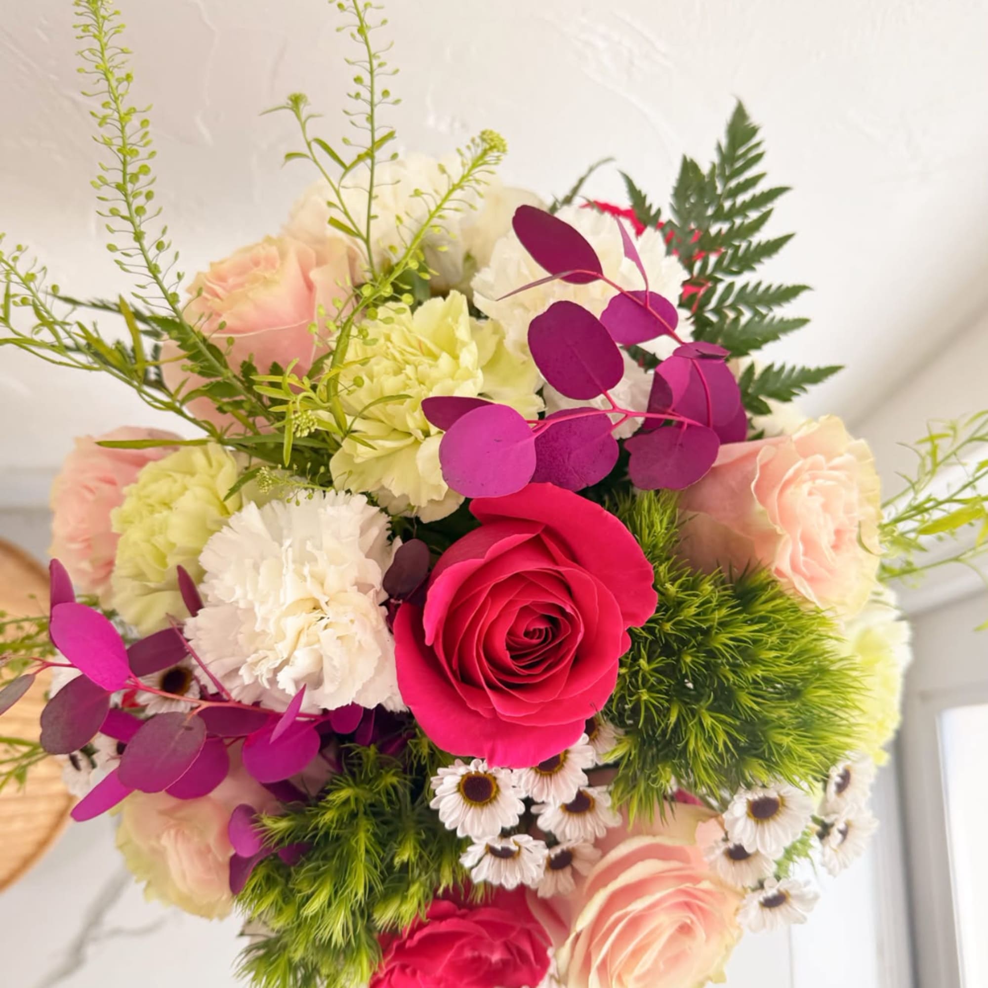Bouquet of pink and white roses with carnations and purple foliage