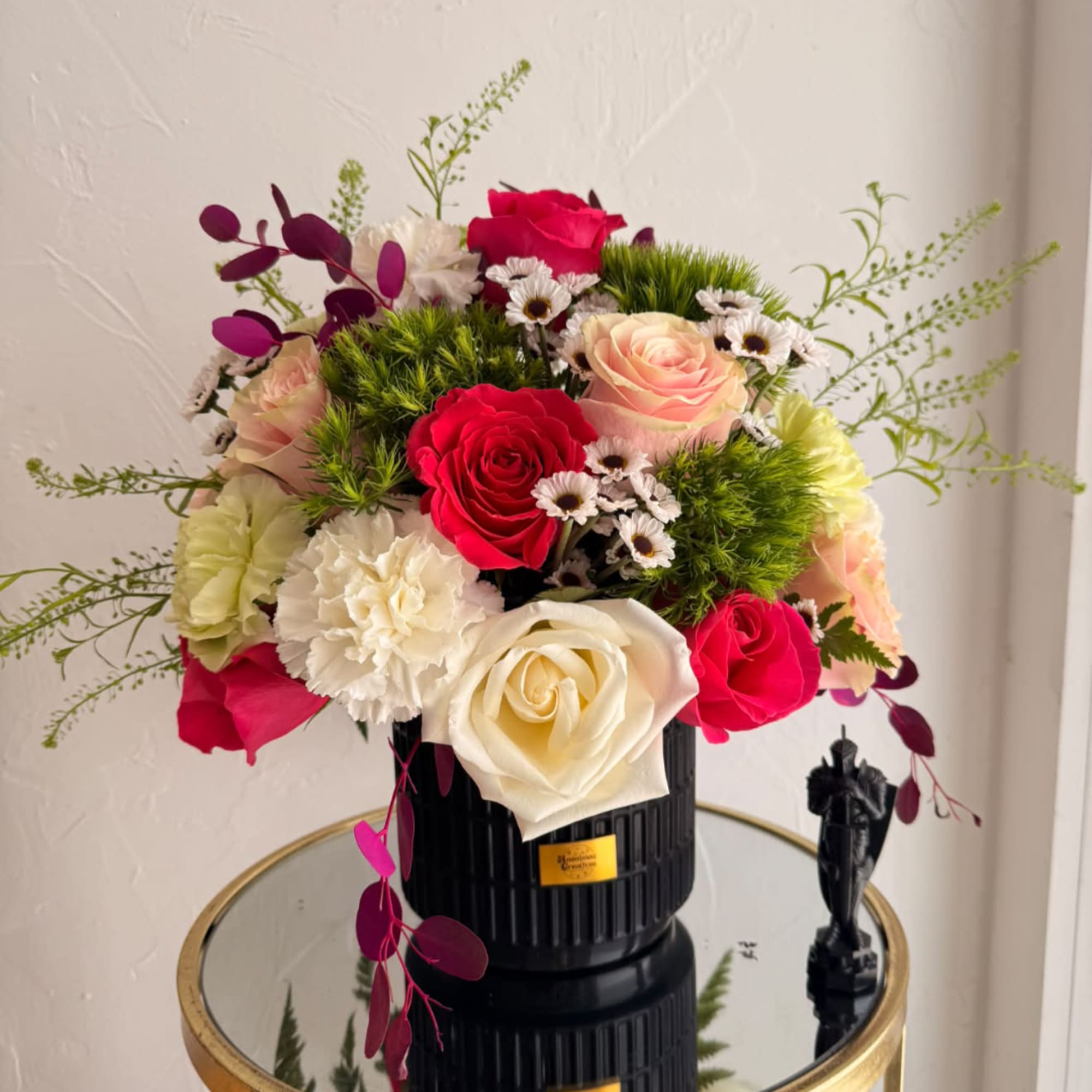 Mixed bouquet of roses, carnations, and daisies in a black vase, photo 3 of 5