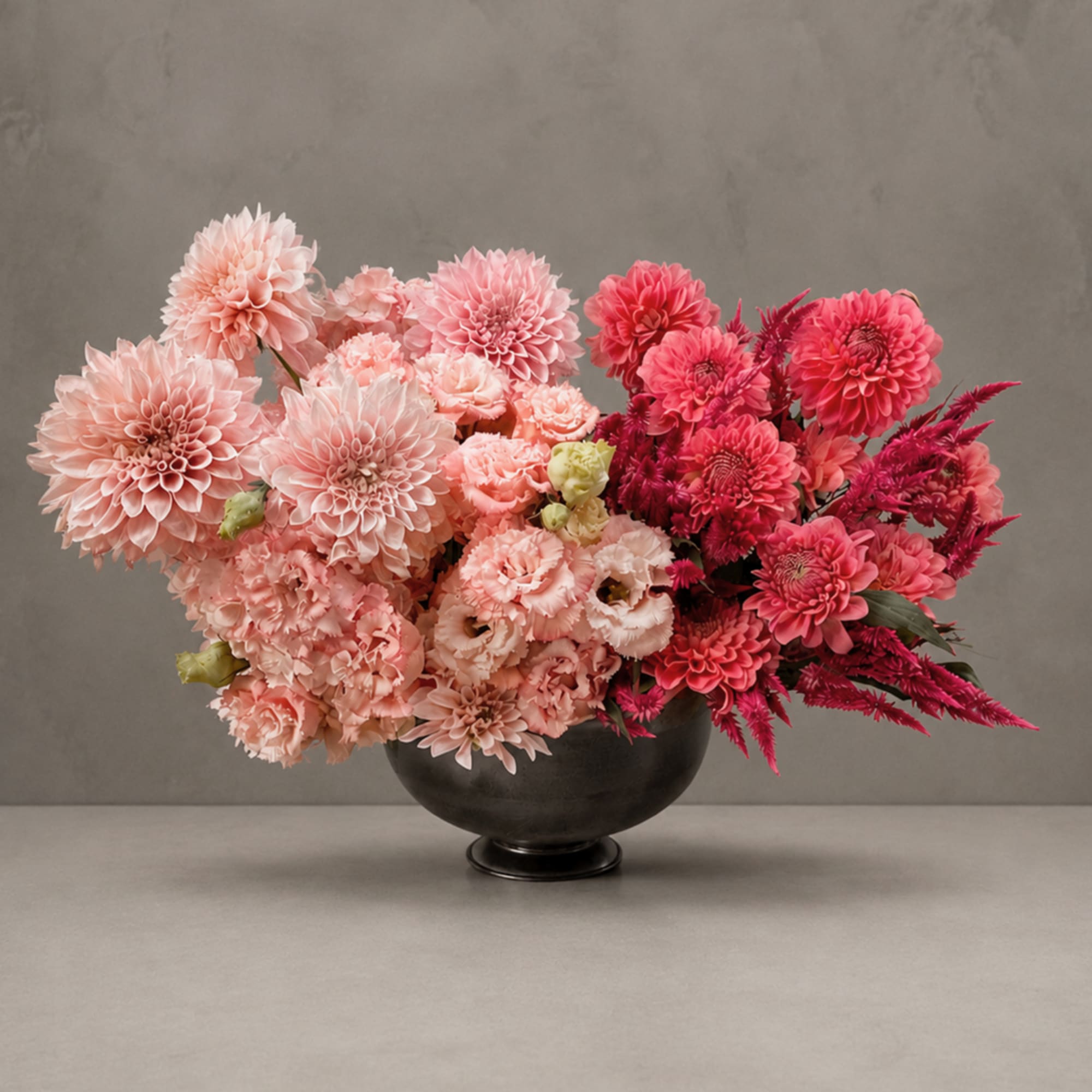 Pink and magenta dahlia arrangement in a black bowl vase