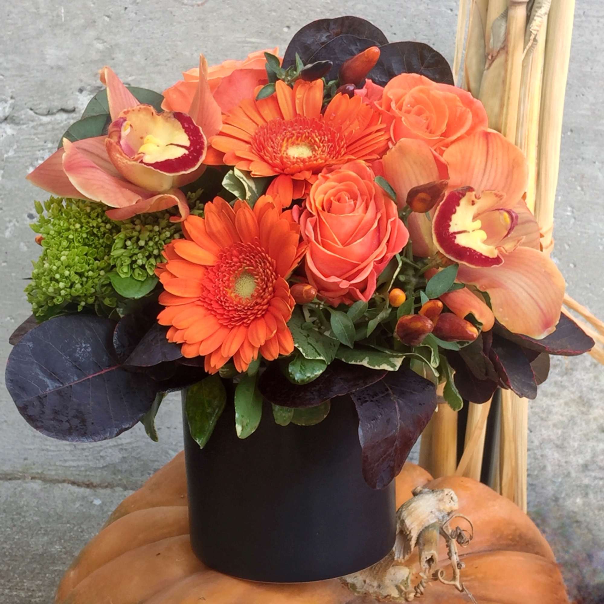 Orange gerbera and rose bouquet in a black vase