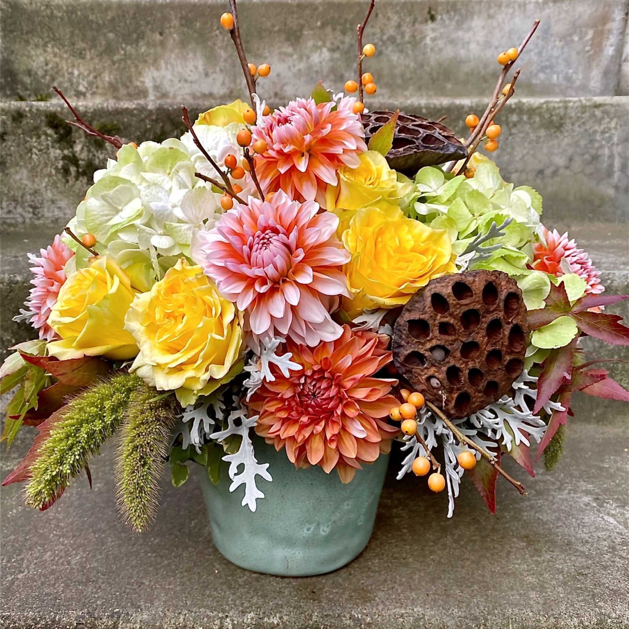 Colorful flower arrangement in a blue pot with yellow and pink blooms