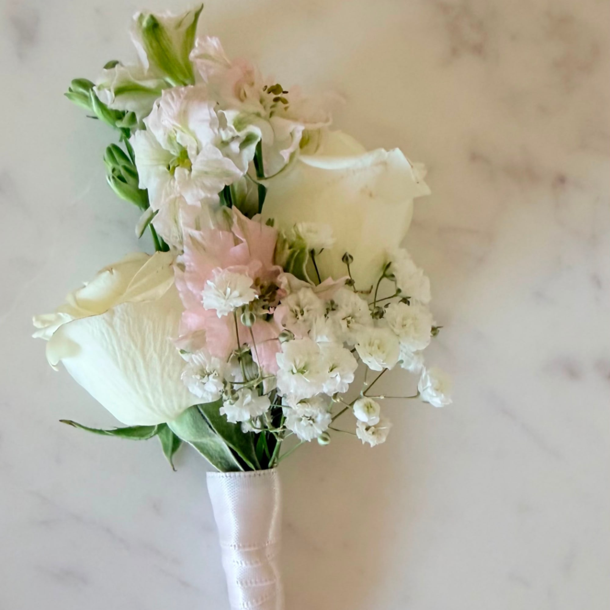 White and blush wedding bouquet with calla lilies and small white flowers