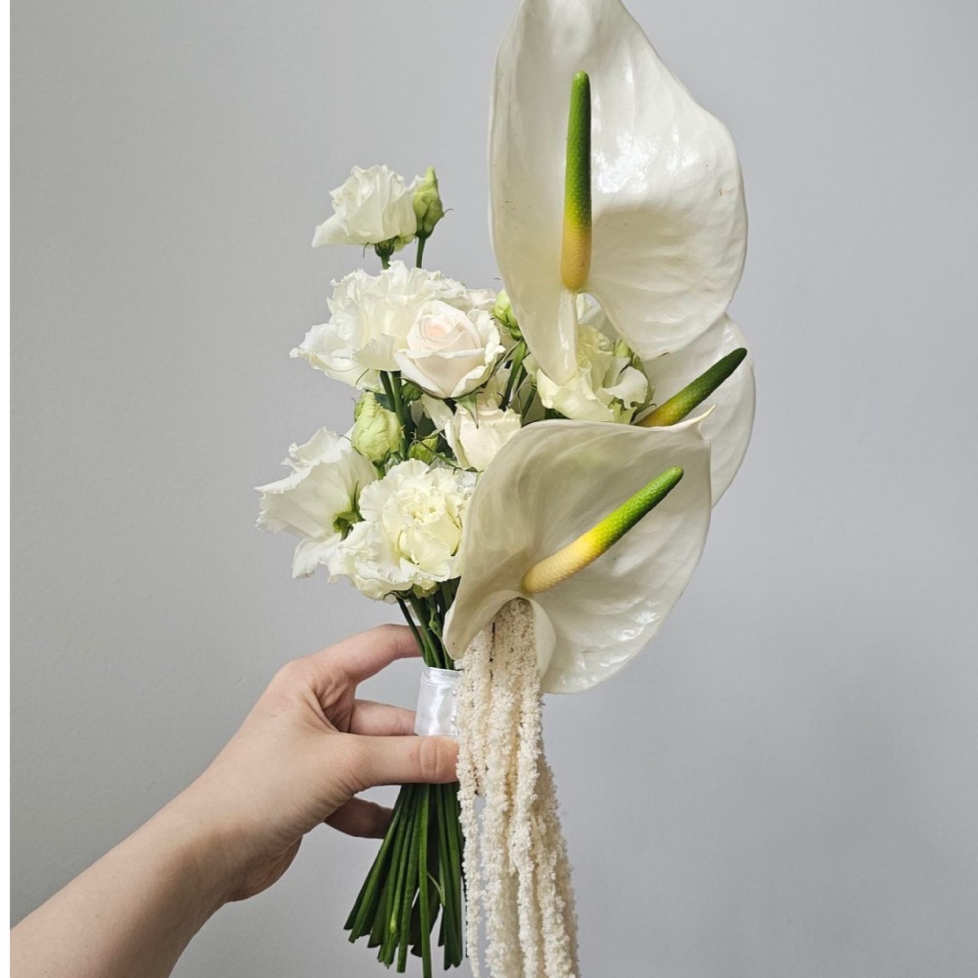 White bridal bouquet with calla lilies, roses, and ruffled blooms