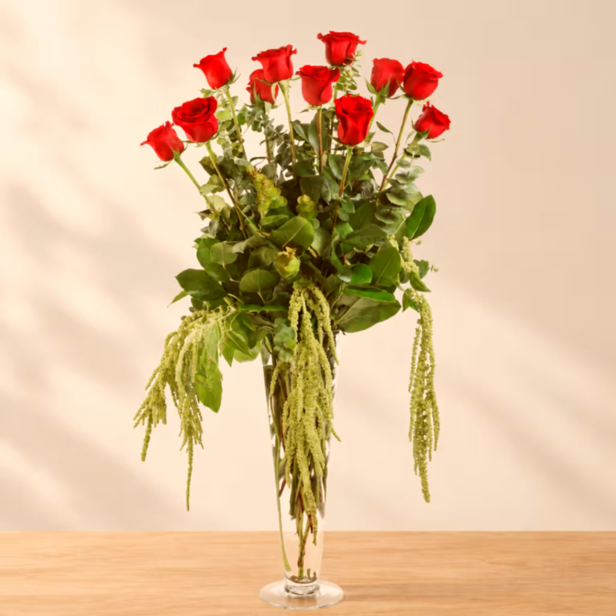 Tall vase arrangement of red roses with trailing greenery, photo 4 of 4