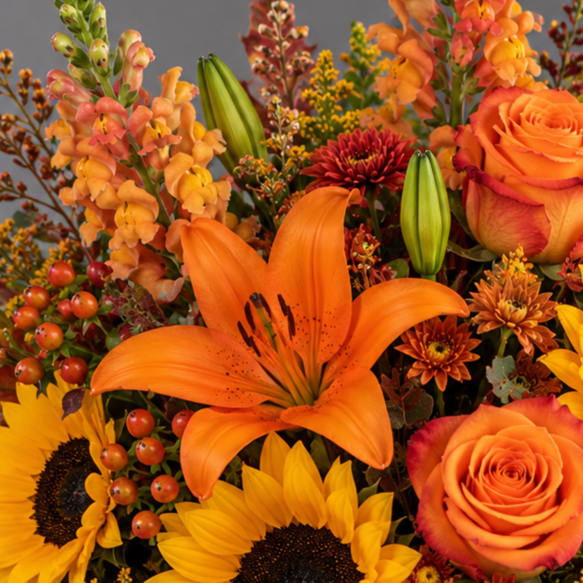 Orange lilies and roses with sunflowers in a mixed bouquet