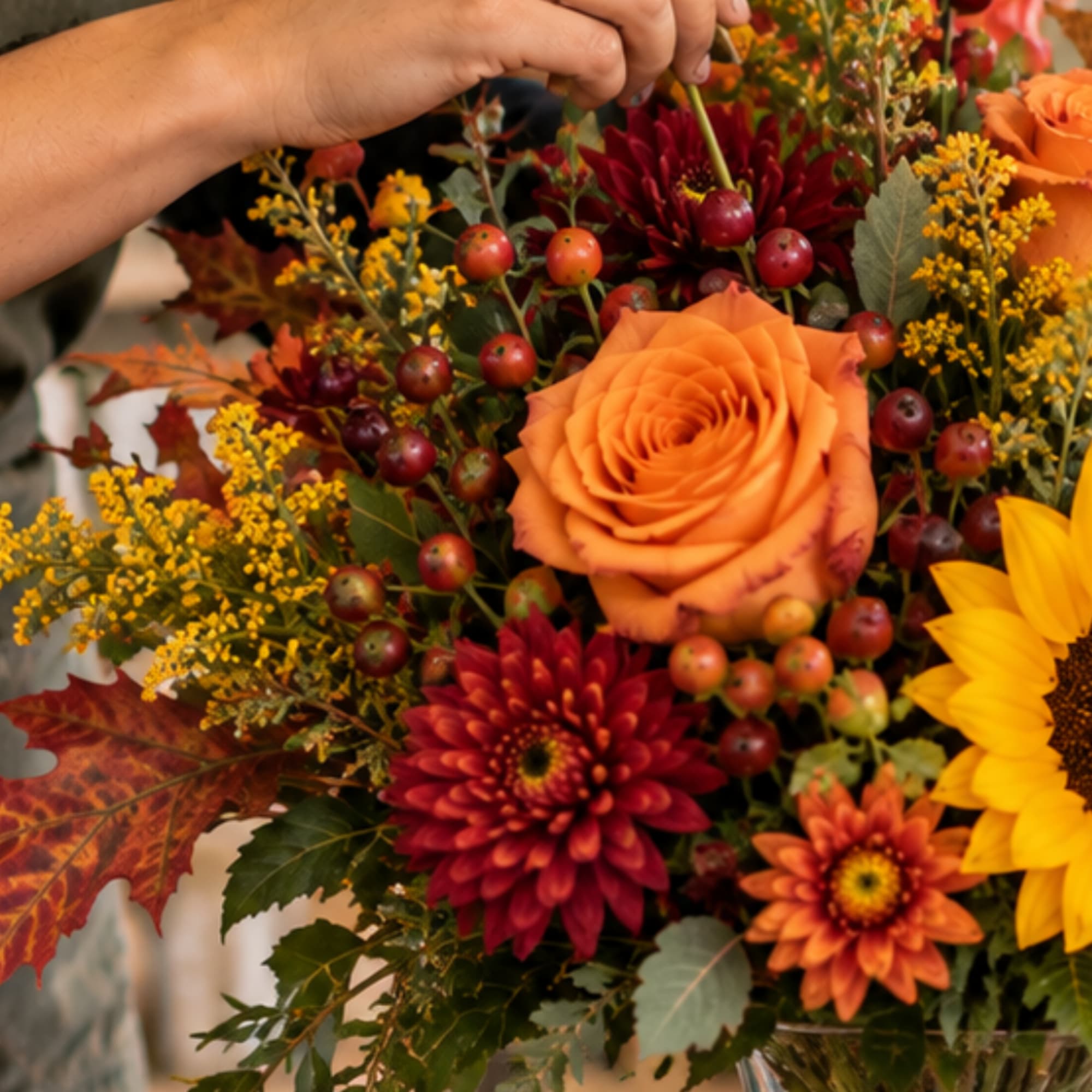 Autumn bouquet with orange roses, red chrysanthemums, and a sunflower