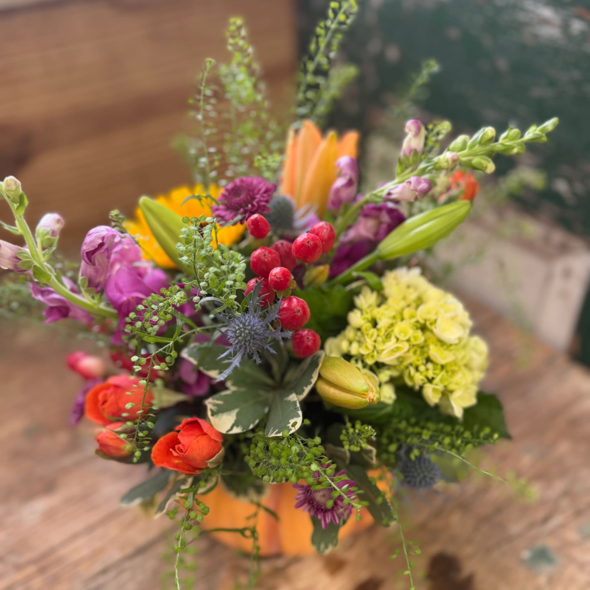 Colorful mixed bouquet with orange, purple, yellow, and red blooms in a vase