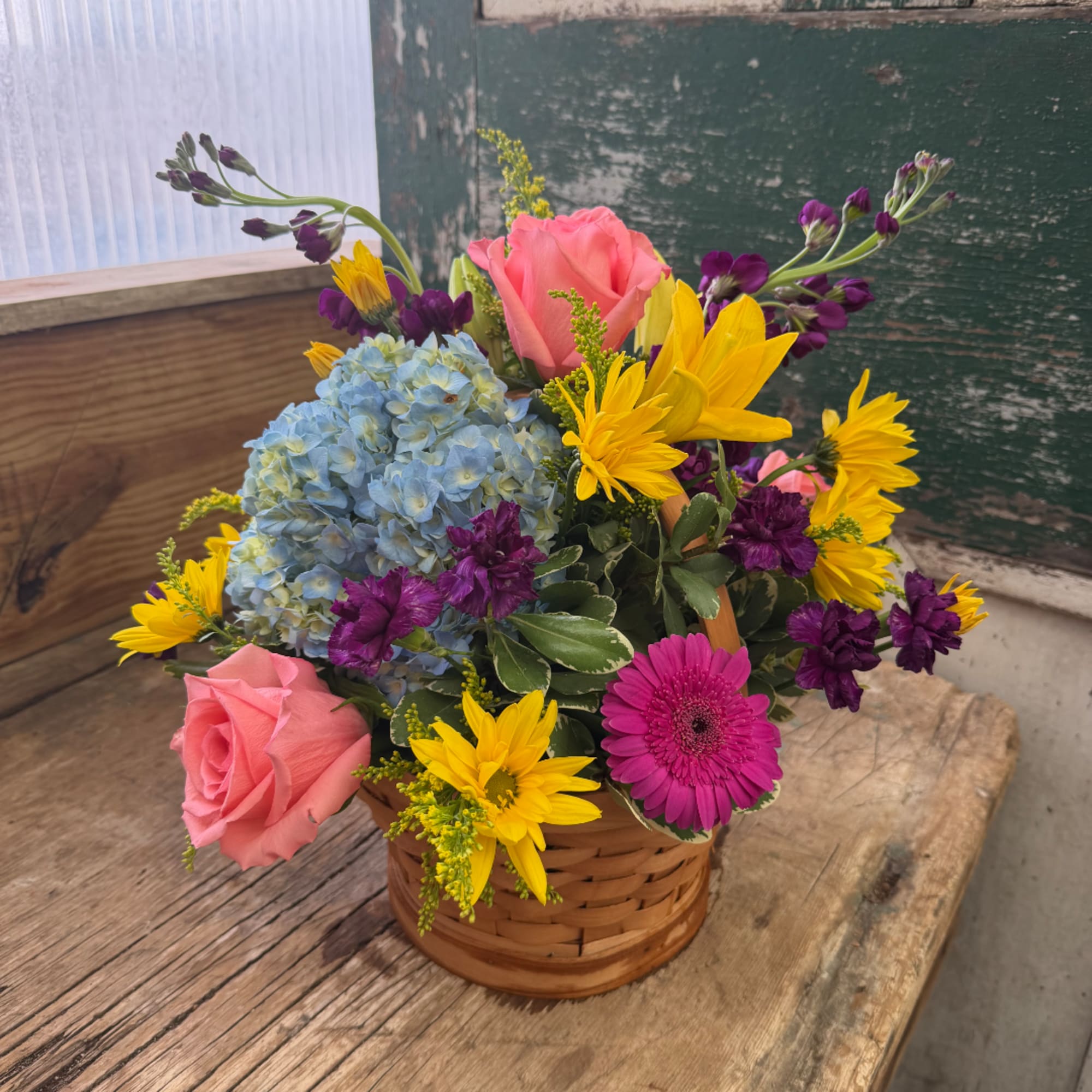 Basket arrangement with pink roses, blue hydrangea, yellow daisies, and purple flowers, photo 4 of 5