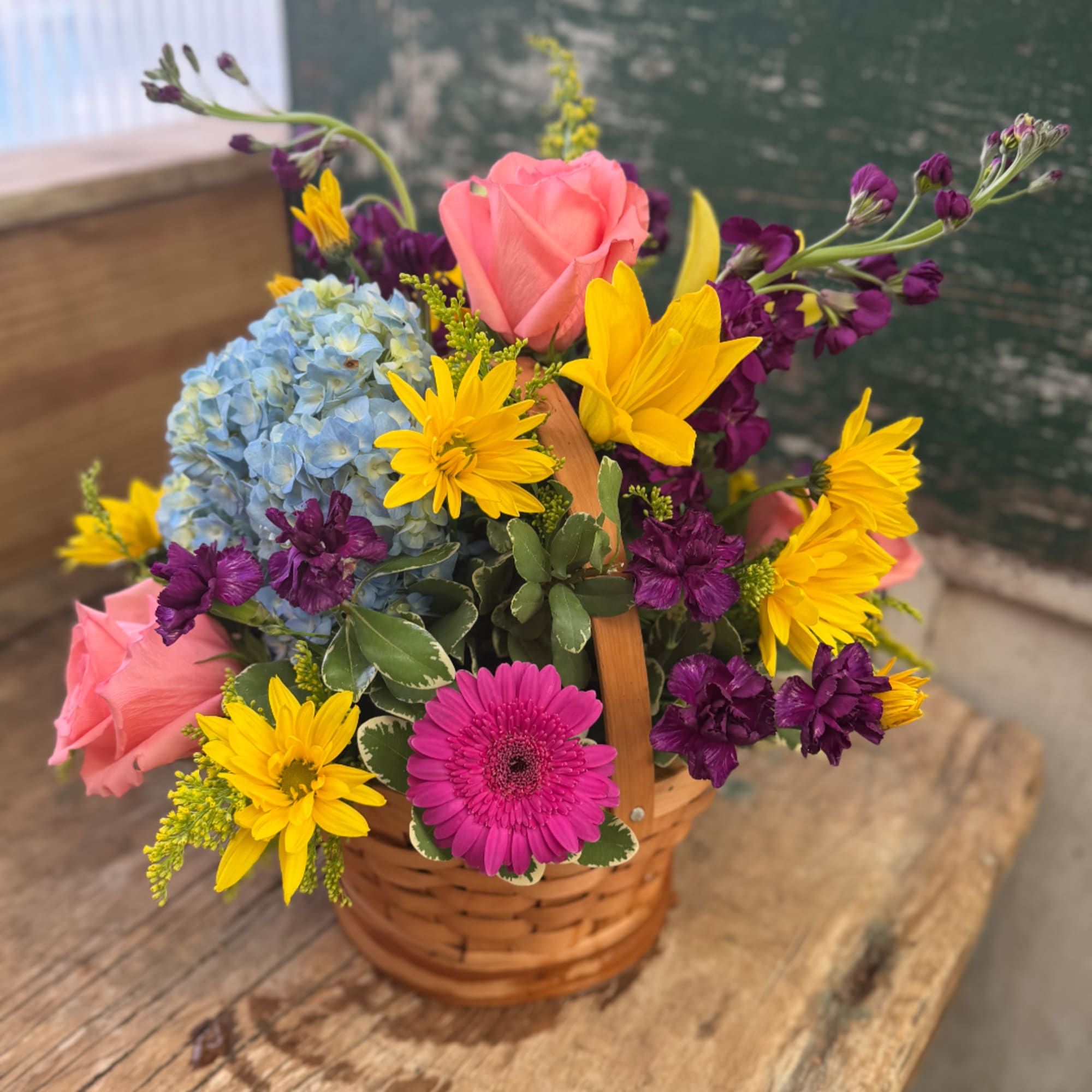 Basket arrangement with pink roses, blue hydrangea, yellow daisies, and purple flowers, photo 3 of 5