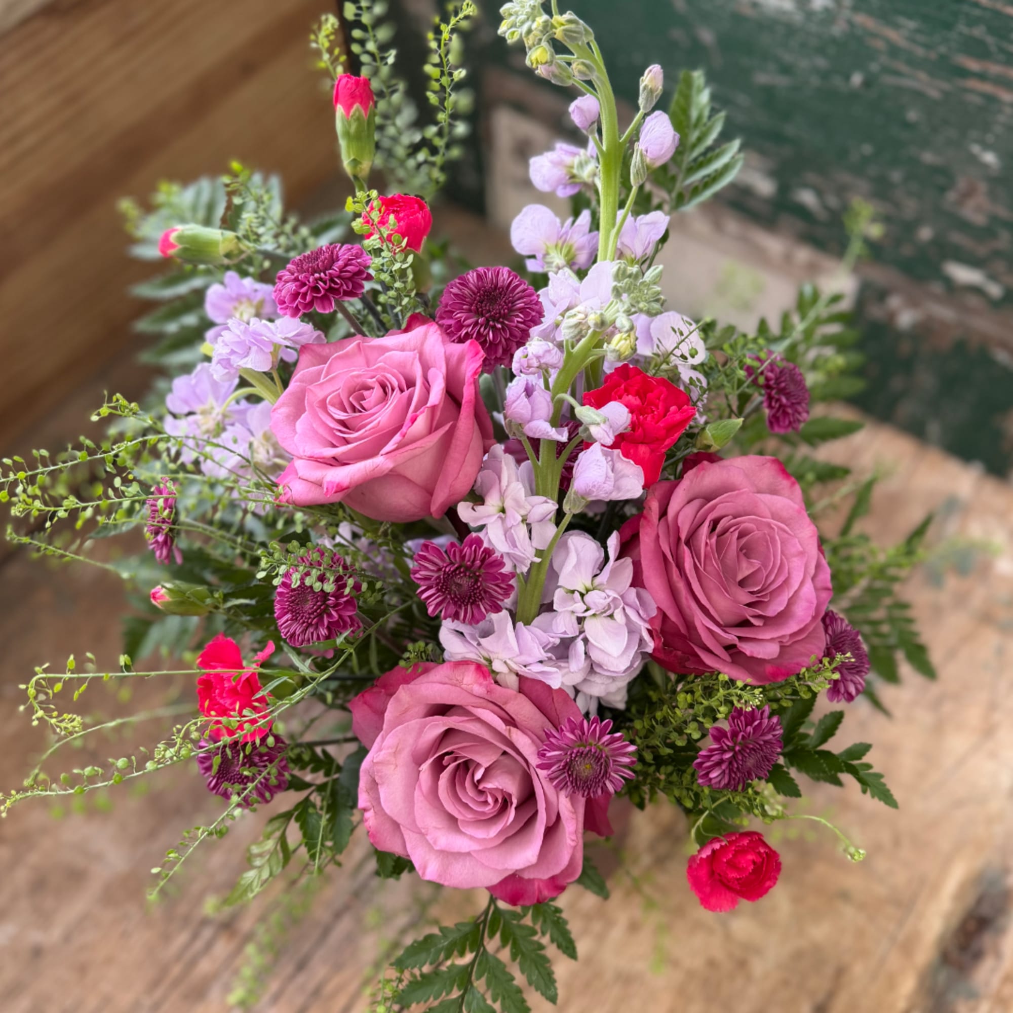 Pink roses and purple flowers in a mixed bouquet
