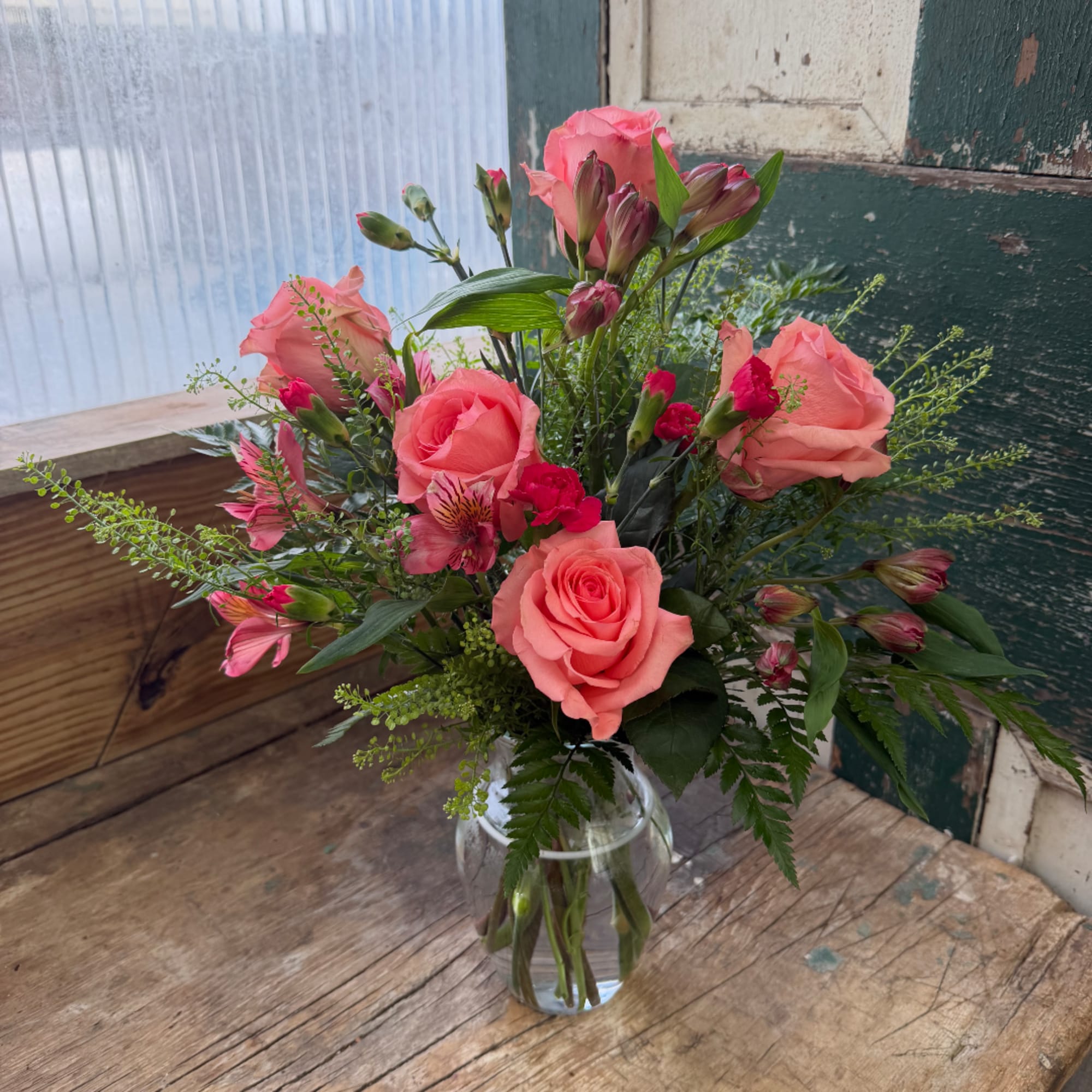 Pink roses and alstroemeria in a clear glass vase