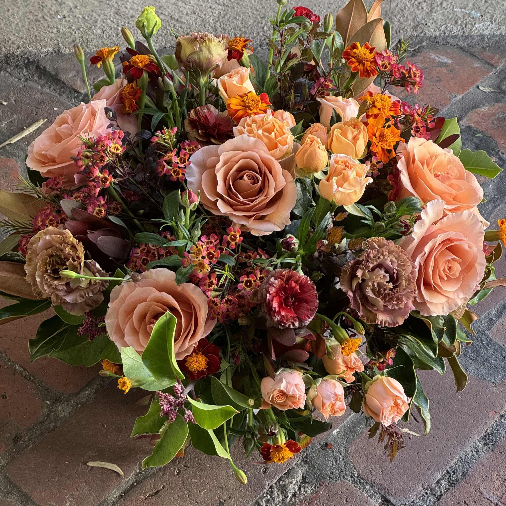 Peach and orange mixed bouquet with roses and small accent flowers