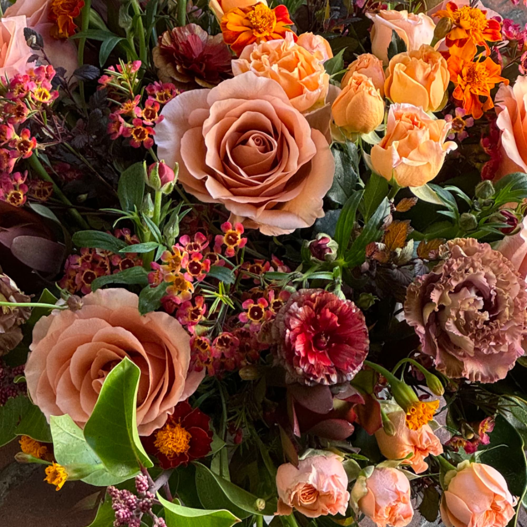 Bouquet of peach roses and mixed orange flowers