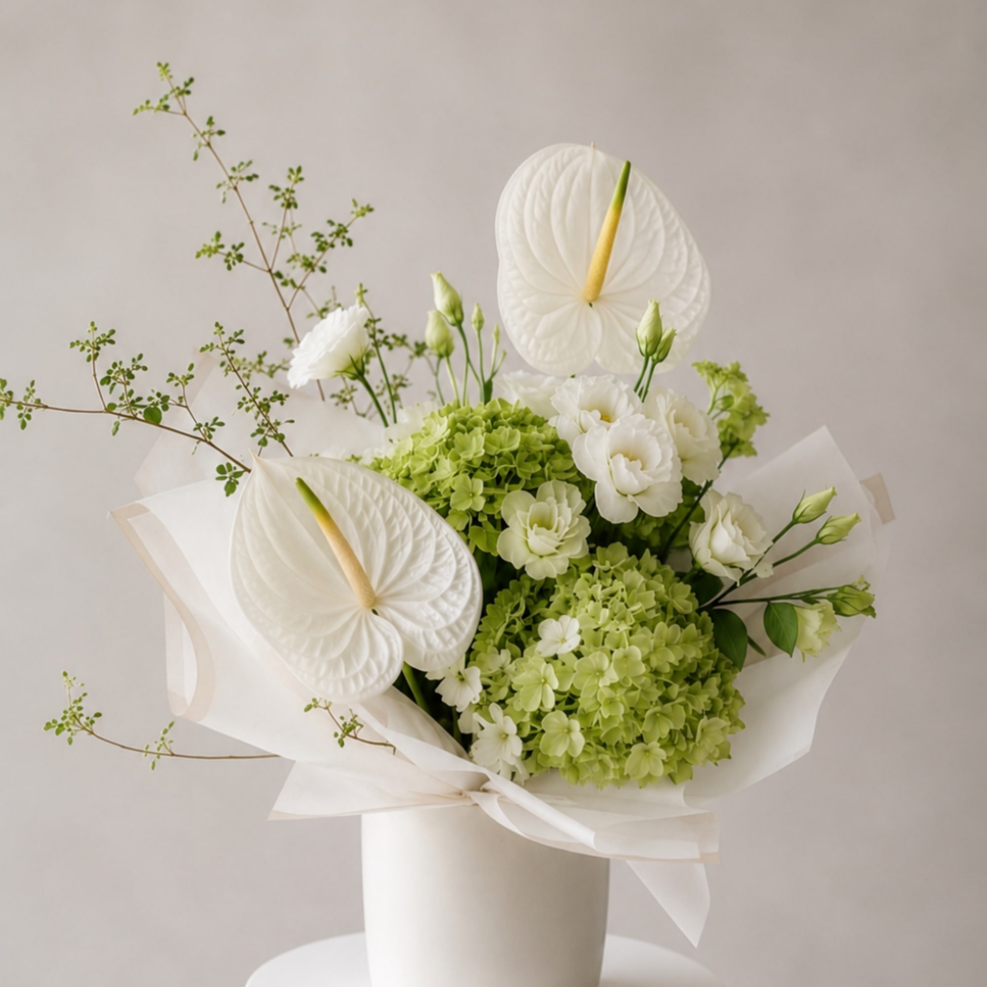 White anthuriums and green hydrangeas in a white vase