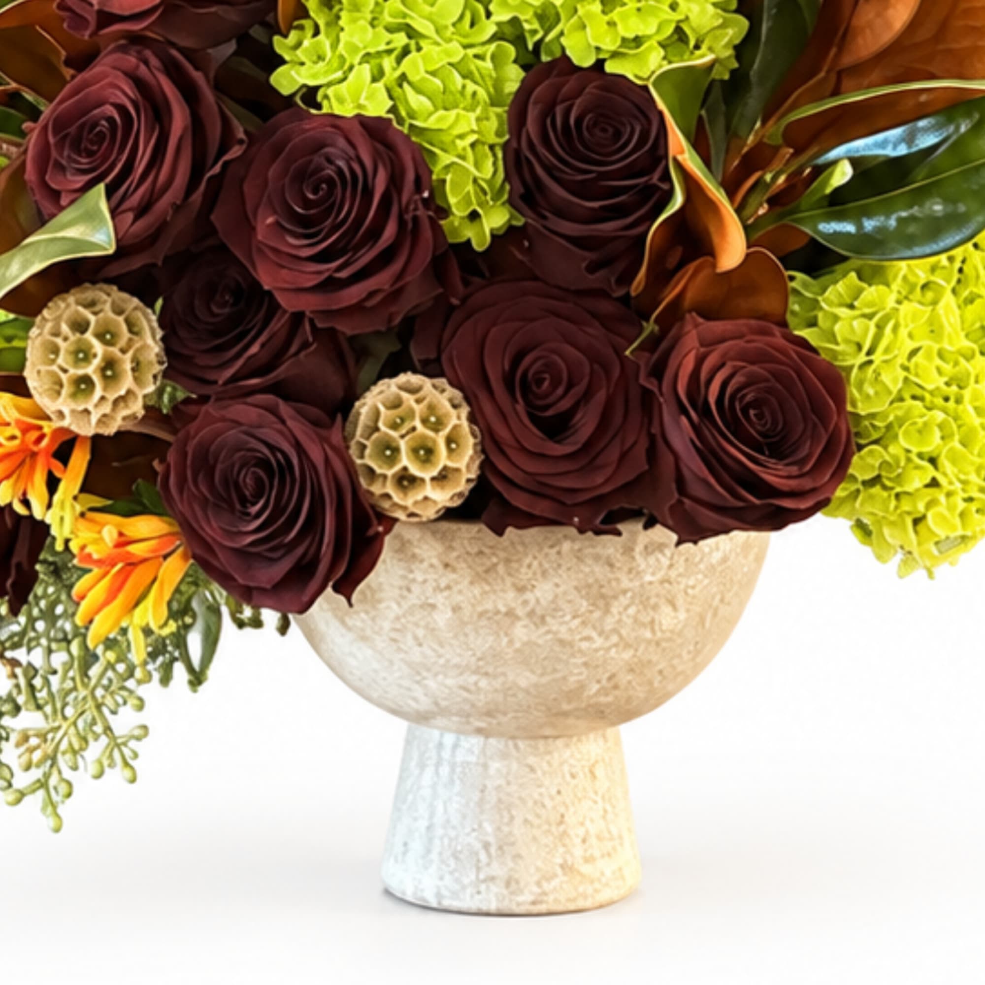 Bouquet of dark red roses and green hydrangeas in a beige vase