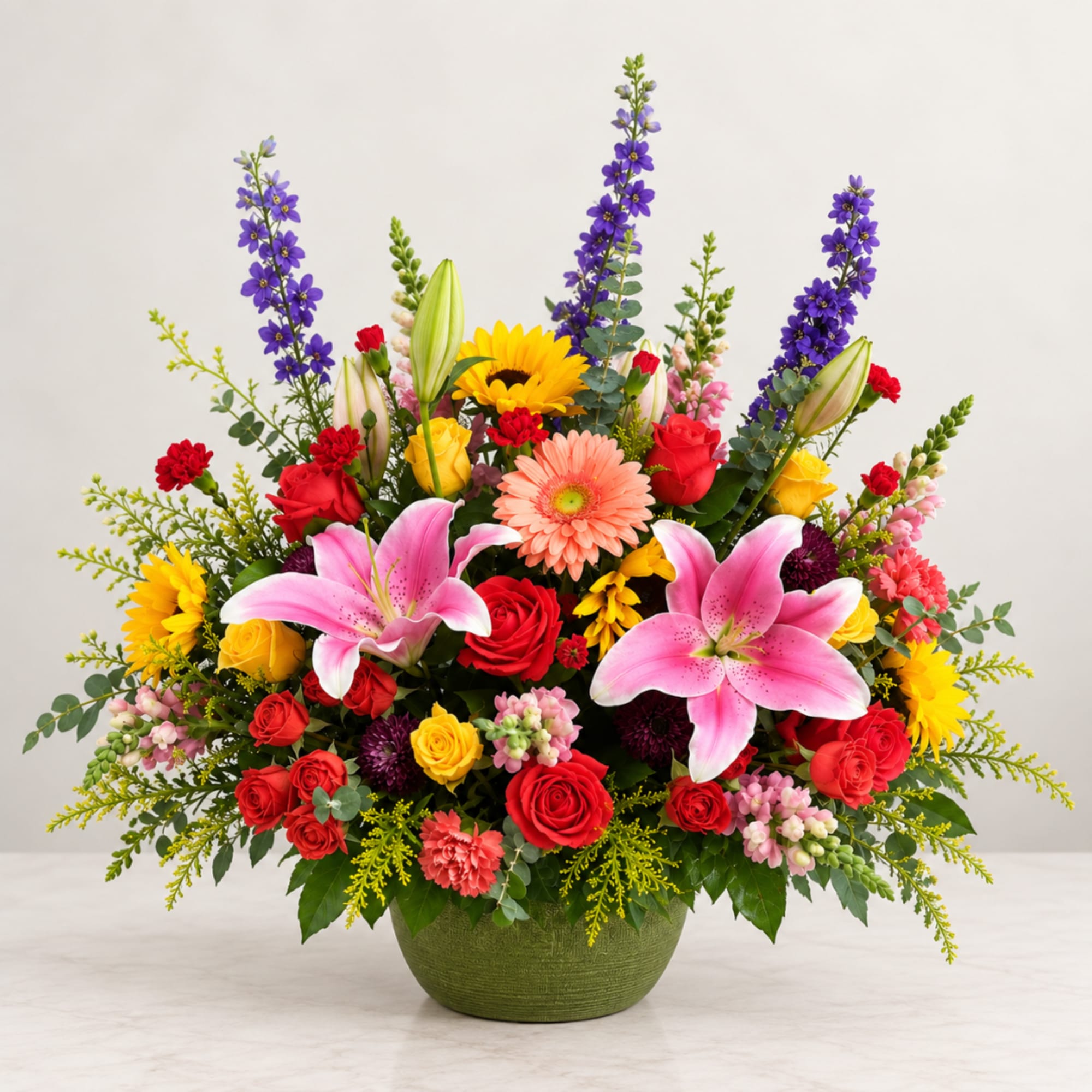 Colorful mixed flower arrangement in a green bowl vase with lilies and roses