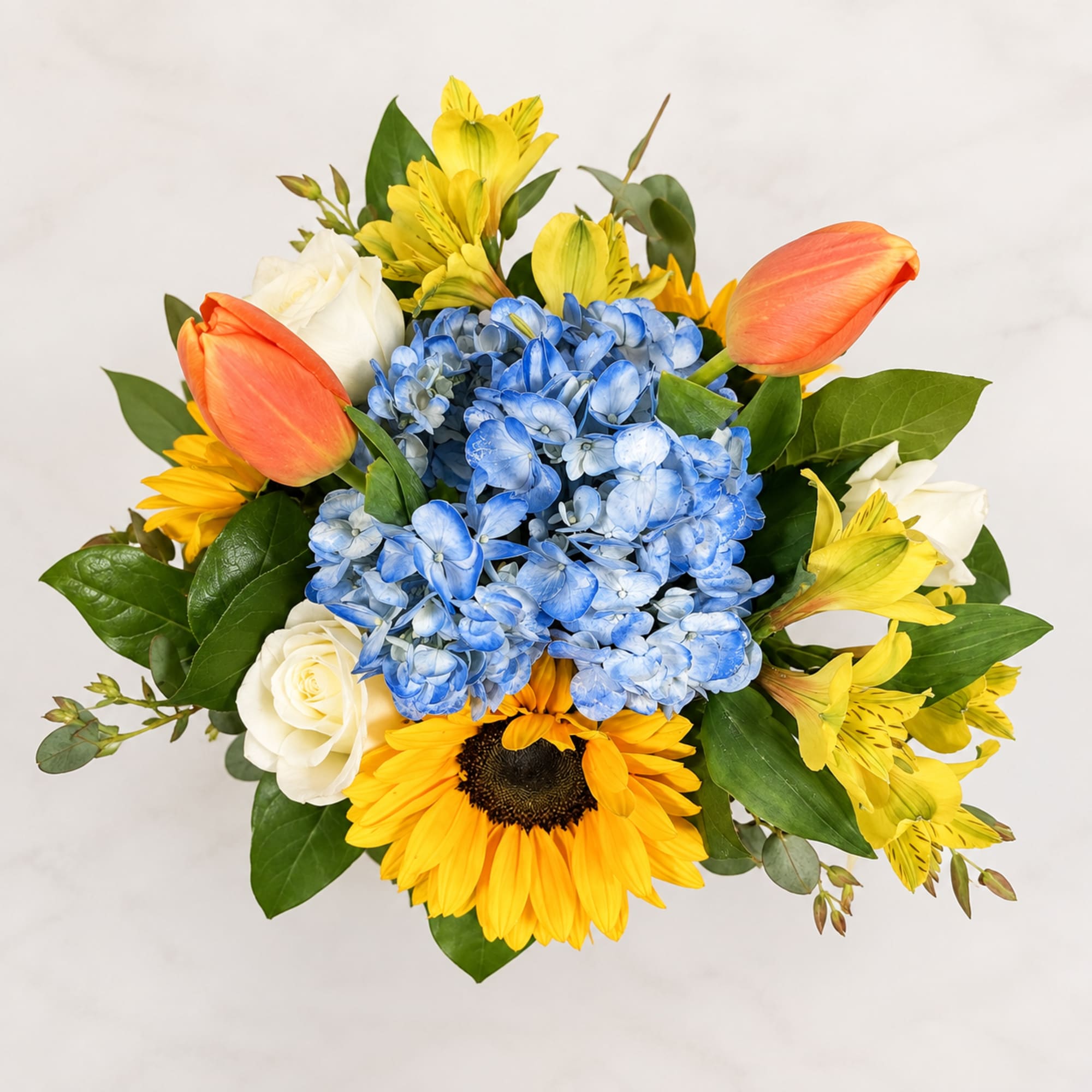 Bouquet with blue hydrangea, yellow flowers, orange tulips, and white roses