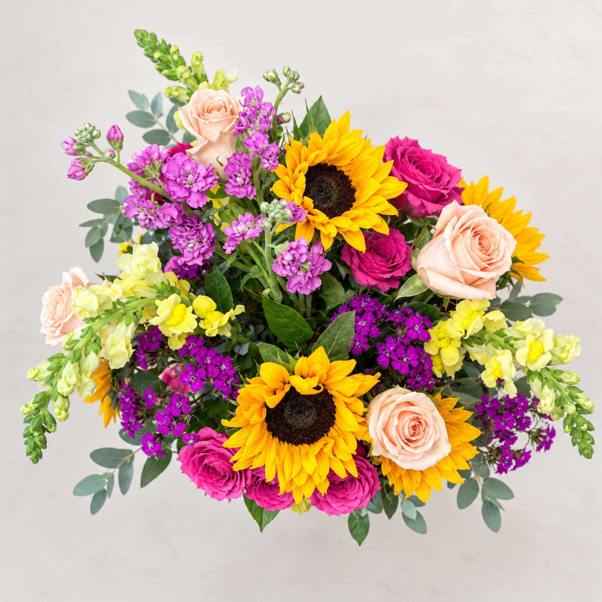 Bright mixed bouquet with sunflowers, roses, and purple blooms