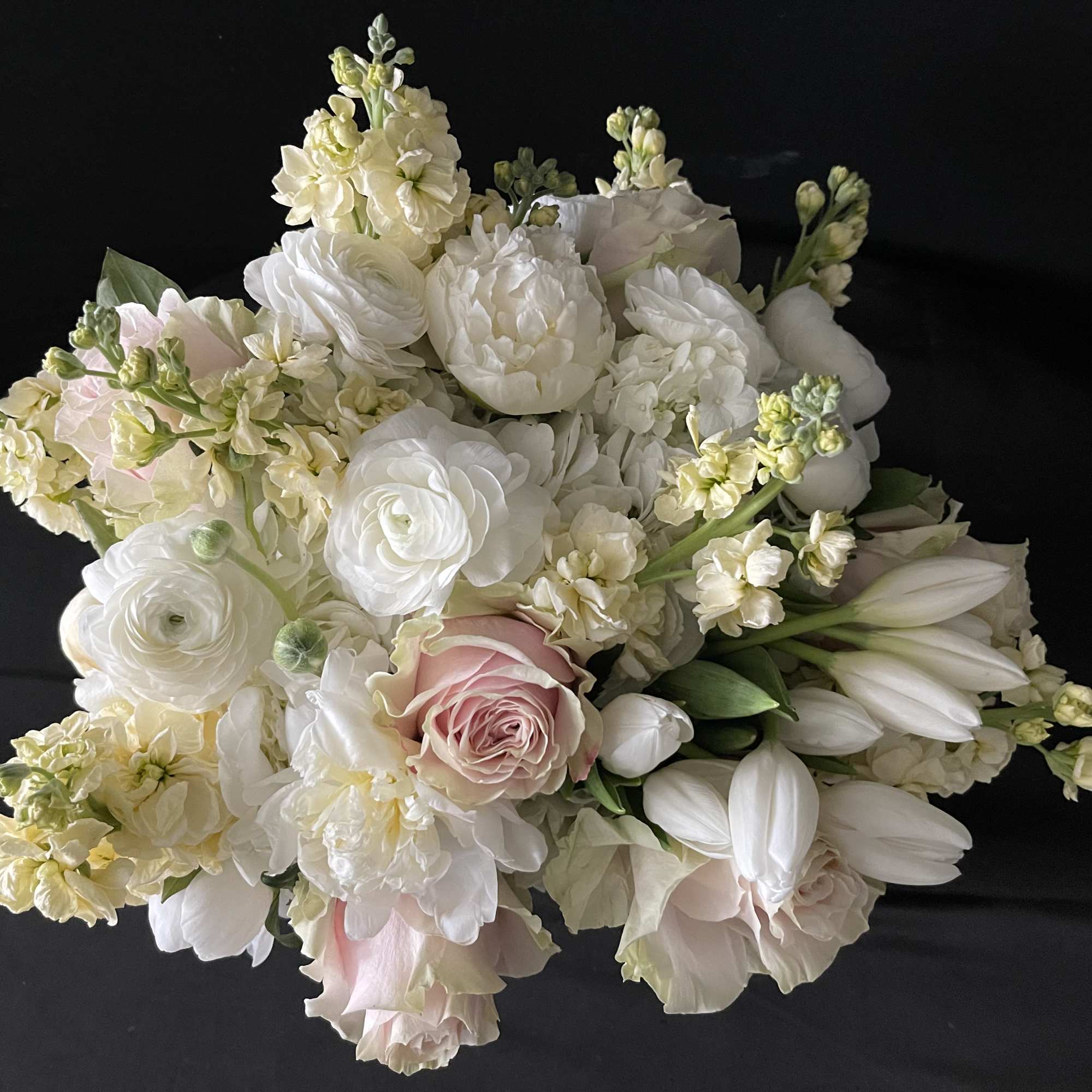 White and blush bouquet with roses, ranunculus, and lilies