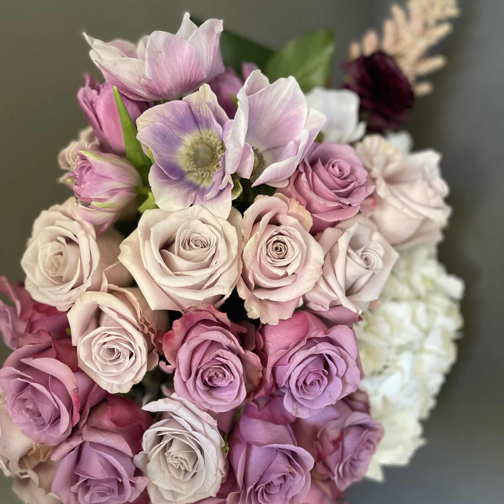 Bouquet of pink and lavender roses with pale anemones
