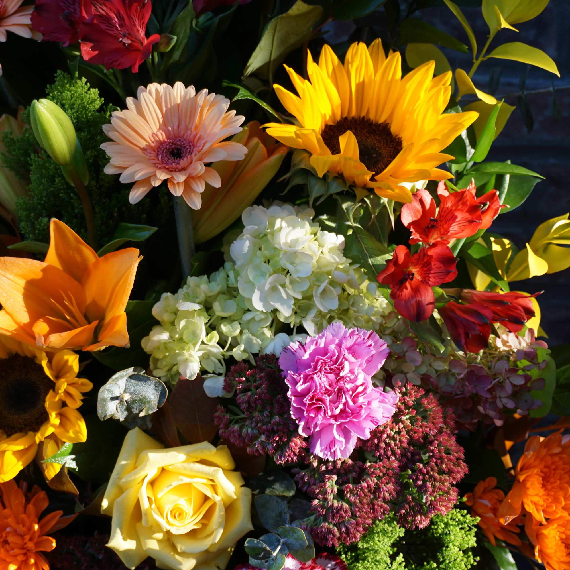 Bright mixed bouquet with sunflowers, roses, hydrangea, and carnations