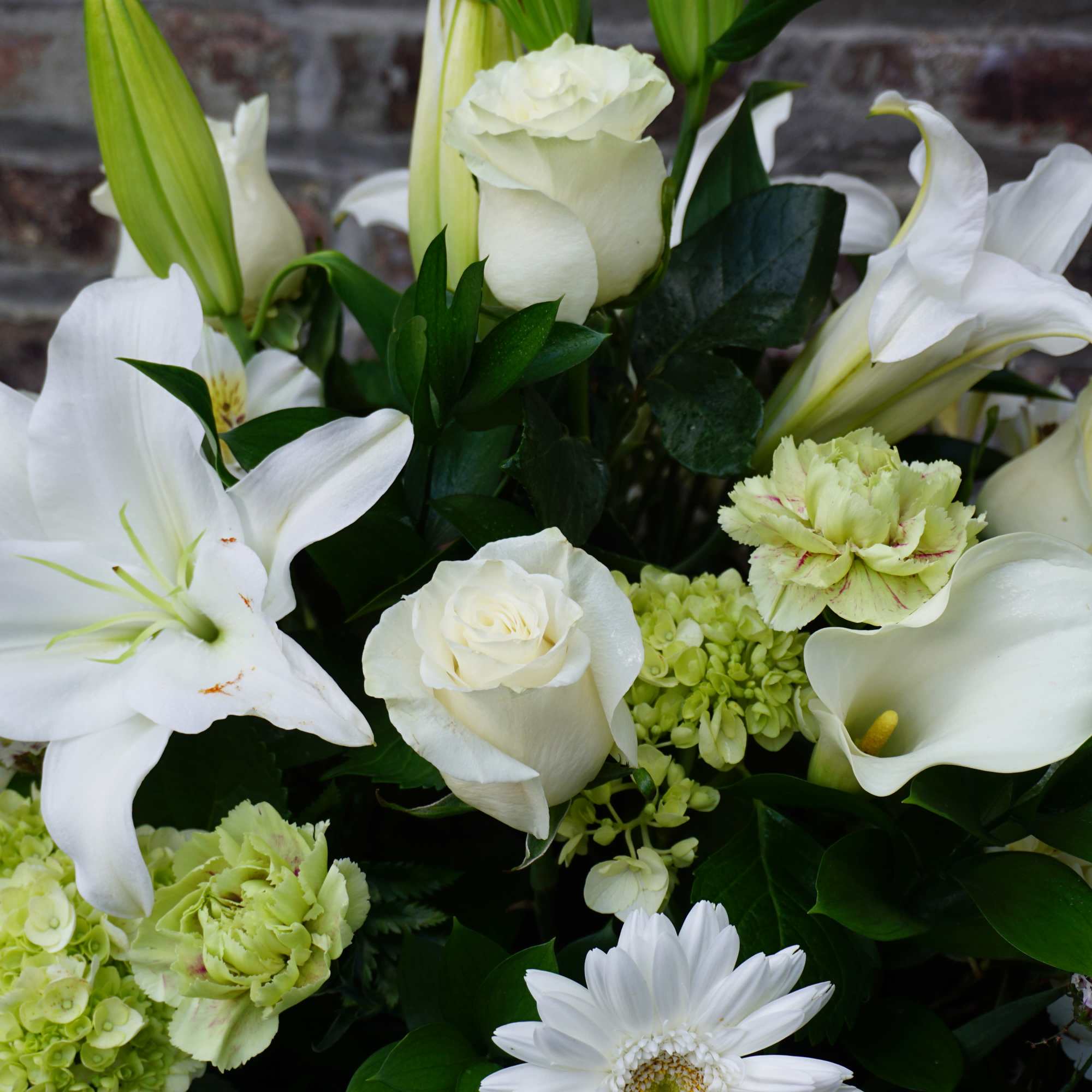 White lilies, roses, calla lilies, and hydrangeas in a bouquet