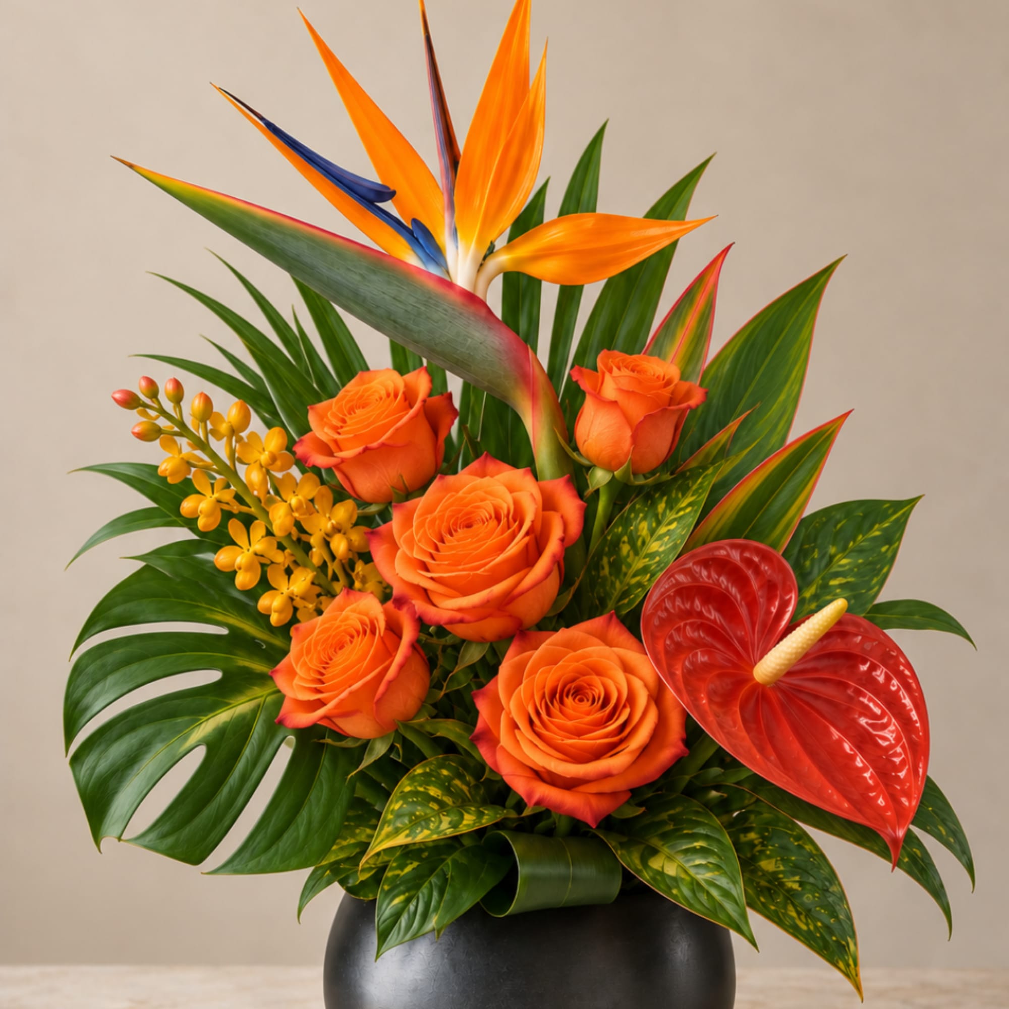 Orange roses and tropical flowers in a black vase