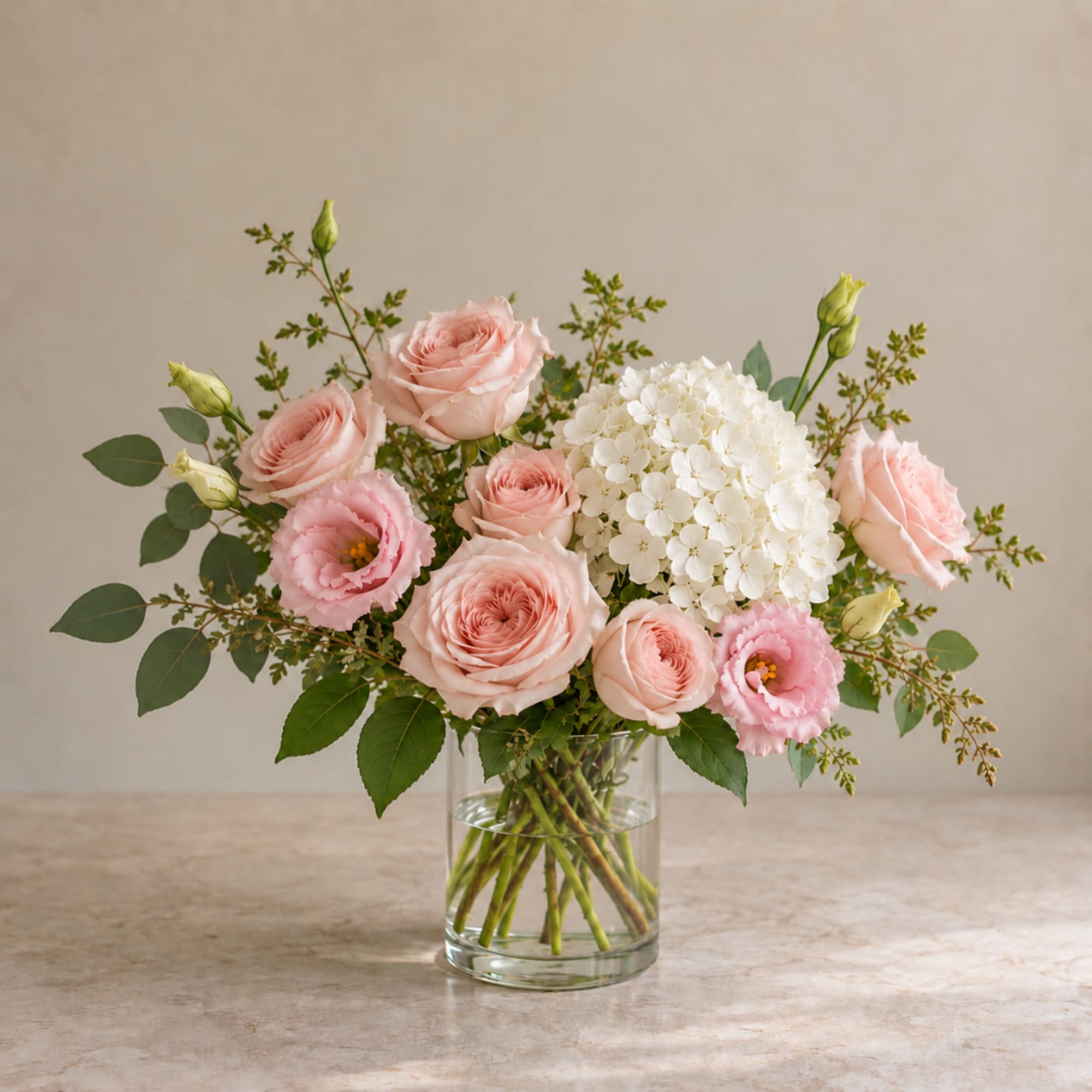 Pink roses and white hydrangea in a clear glass vase