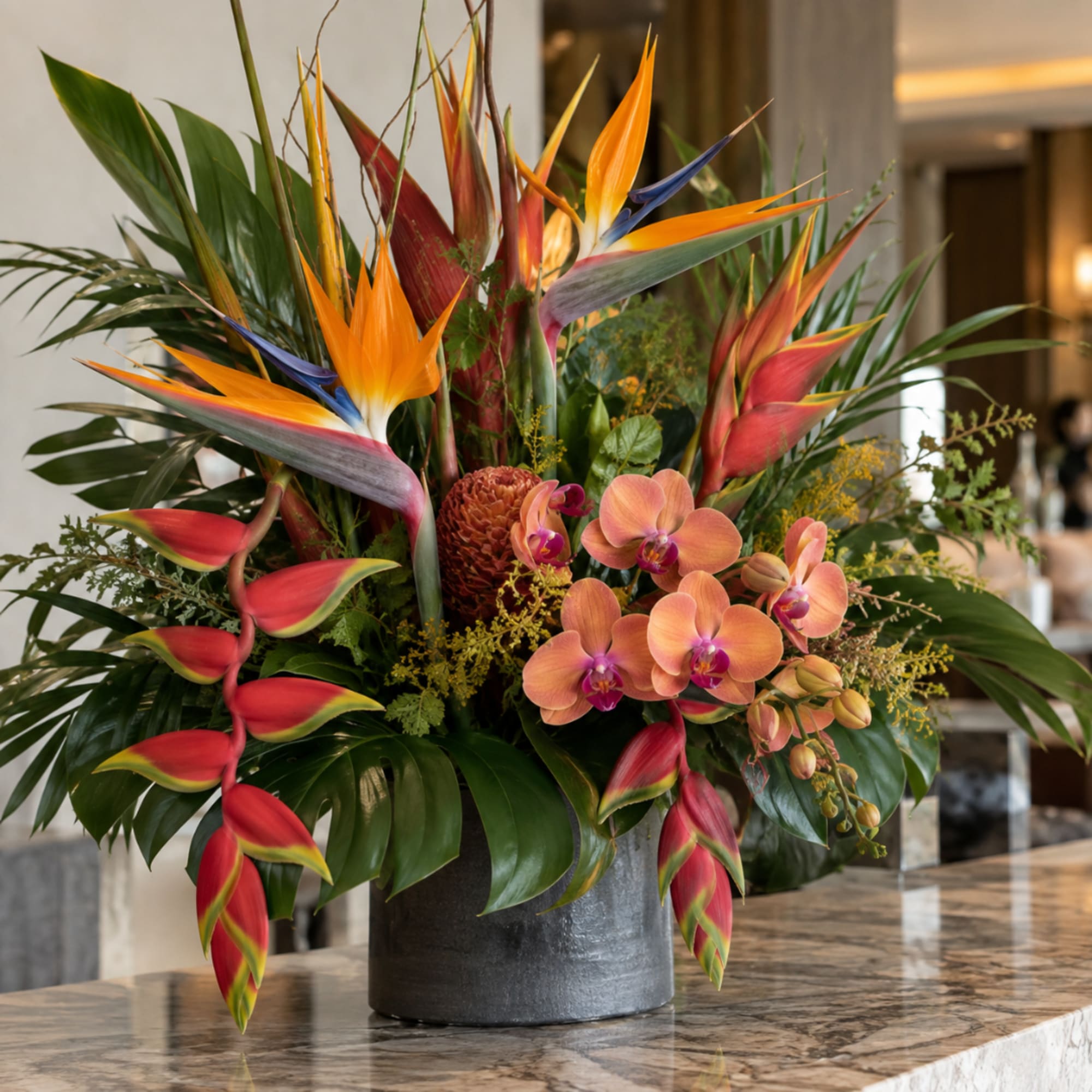 Tropical flower arrangement with bird of paradise and orchids in a dark vase