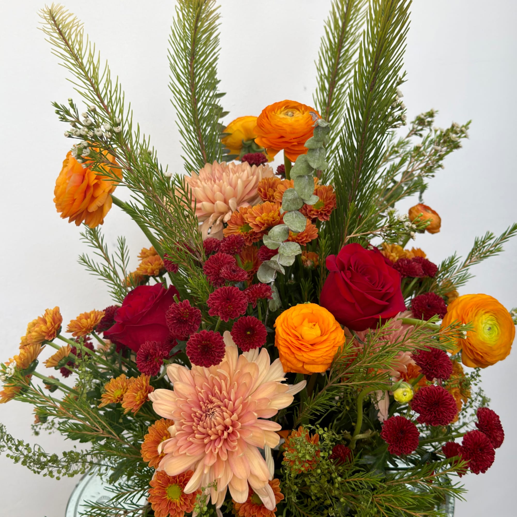 Mixed bouquet with red roses, peach chrysanthemums, and orange ranunculus