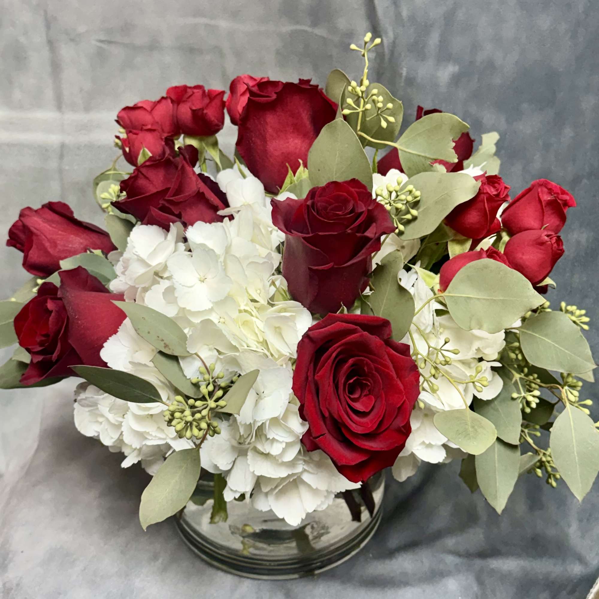 Red roses and white hydrangeas in a glass vase