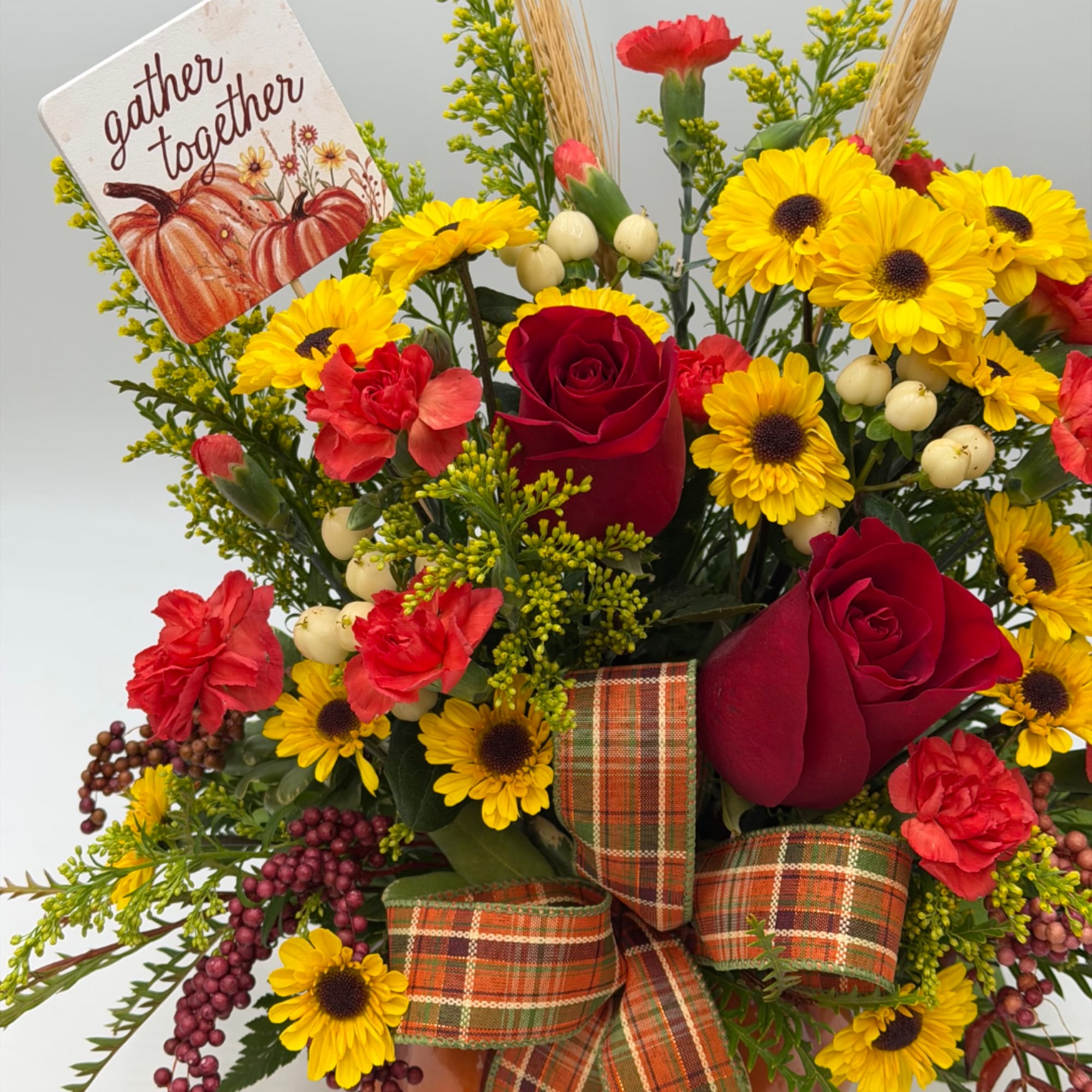 Autumn bouquet with red roses, yellow daisies, and a plaid ribbon