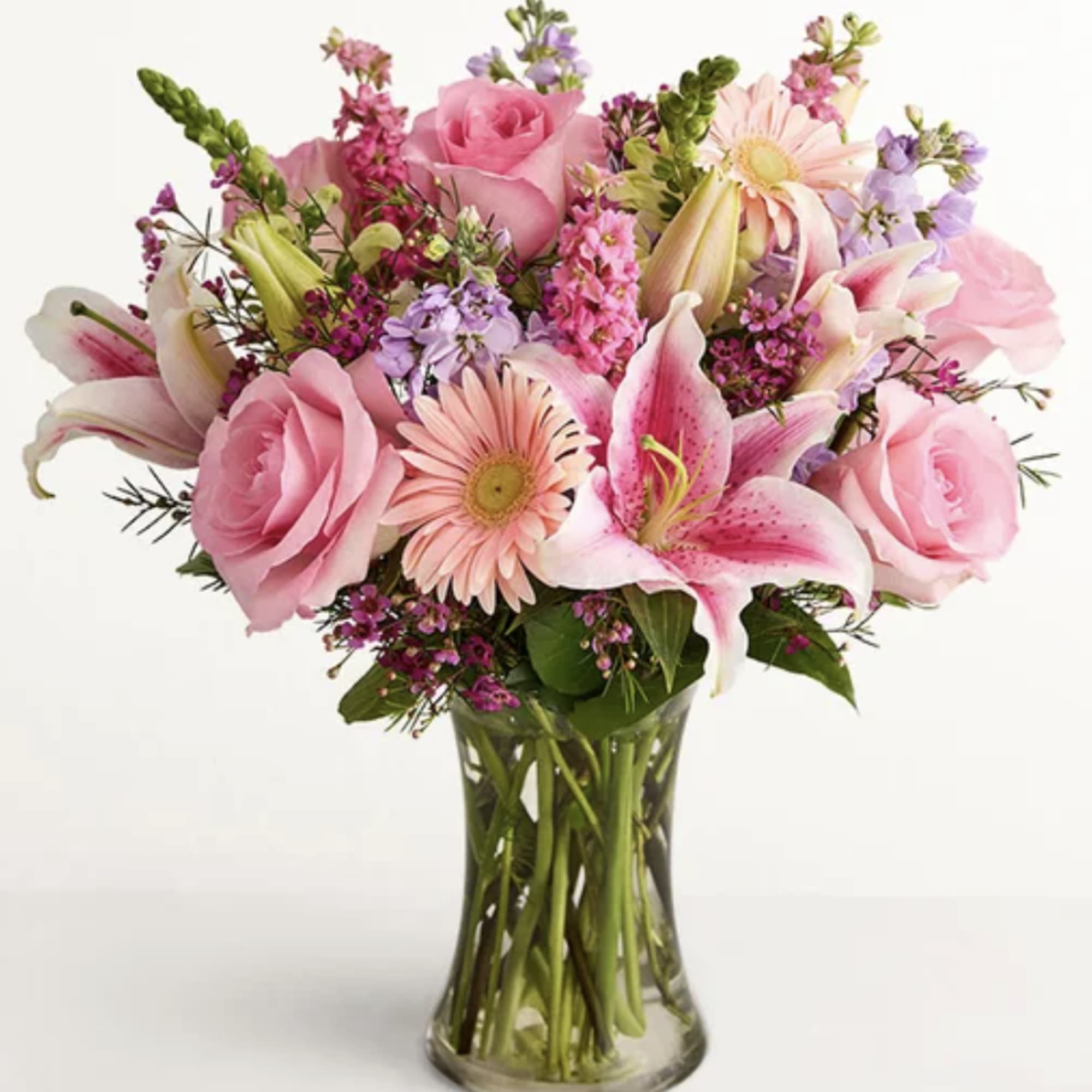 Pink roses and lilies arranged in a clear glass vase, photo 2 of 2