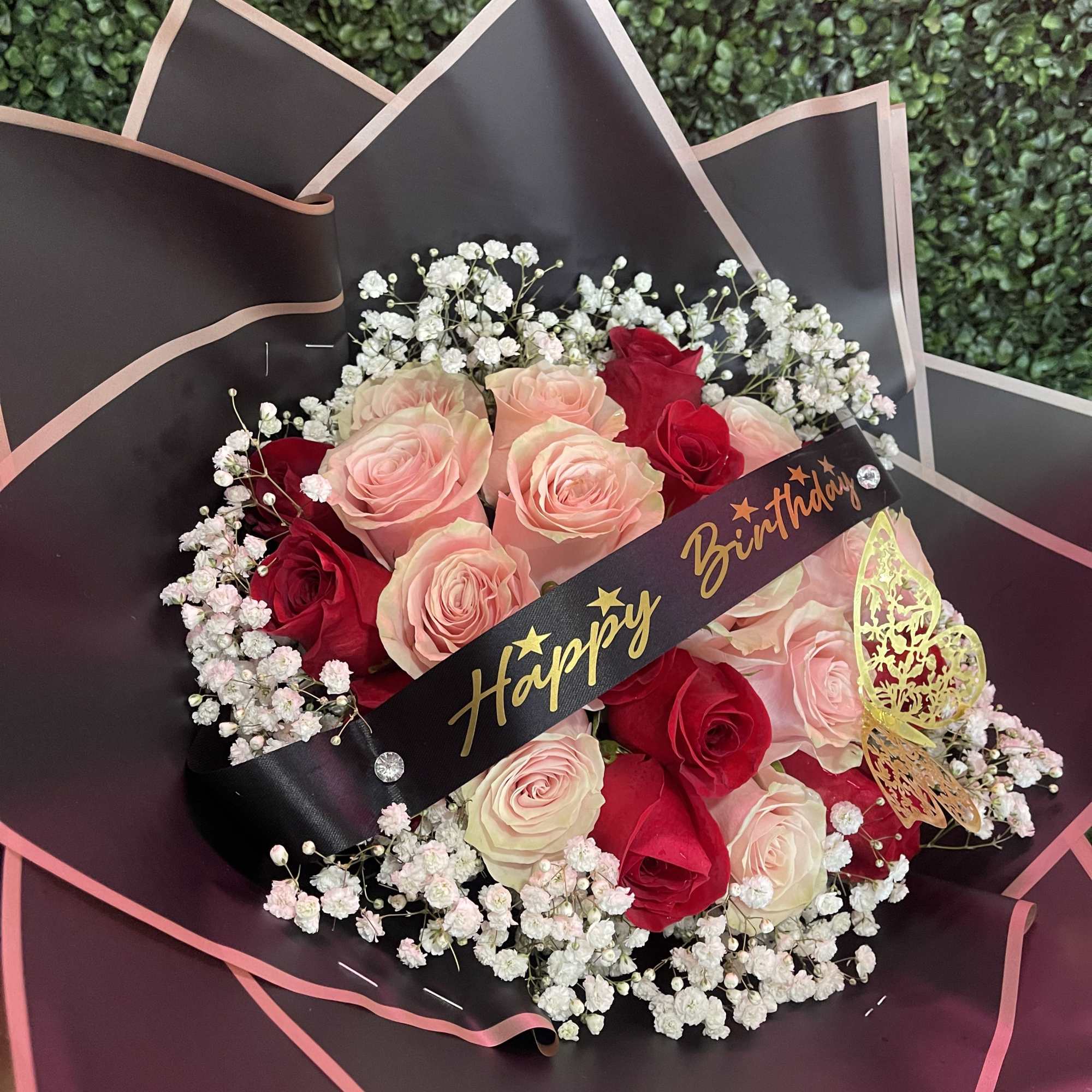 Bouquet of pink and red roses with baby's breath and a Happy Birthday ribbon
